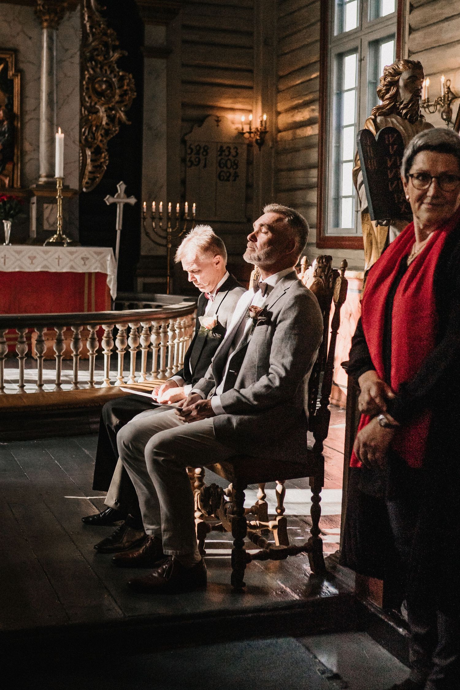Church pews filled with guests in formal attire during a traditional ceremony.