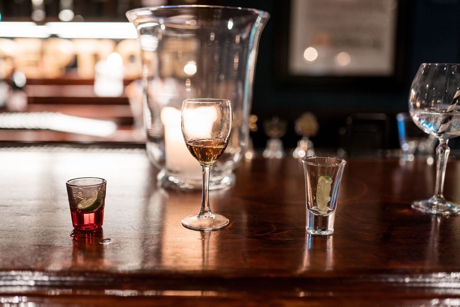 Wine glasses and table settings create an elegant ambiance at a dimly lit reception venue.