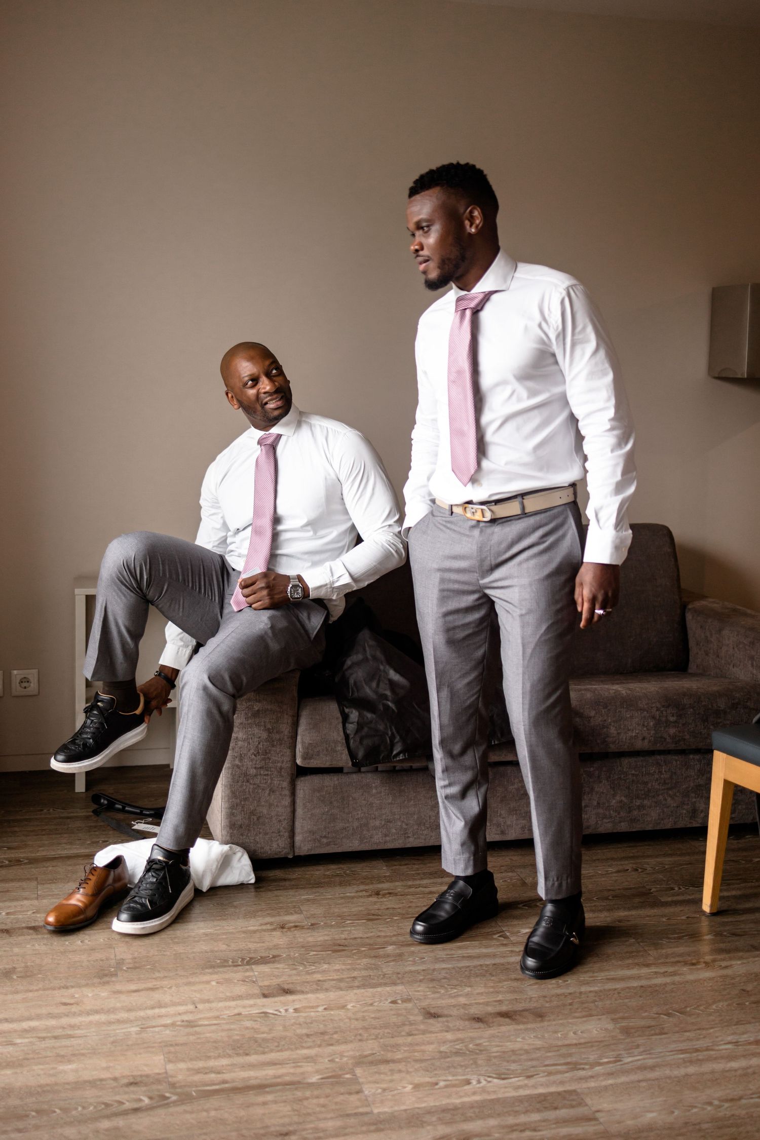 Series of fashion shots showing formal attire with pink tie and grey pants on wooden flooring.