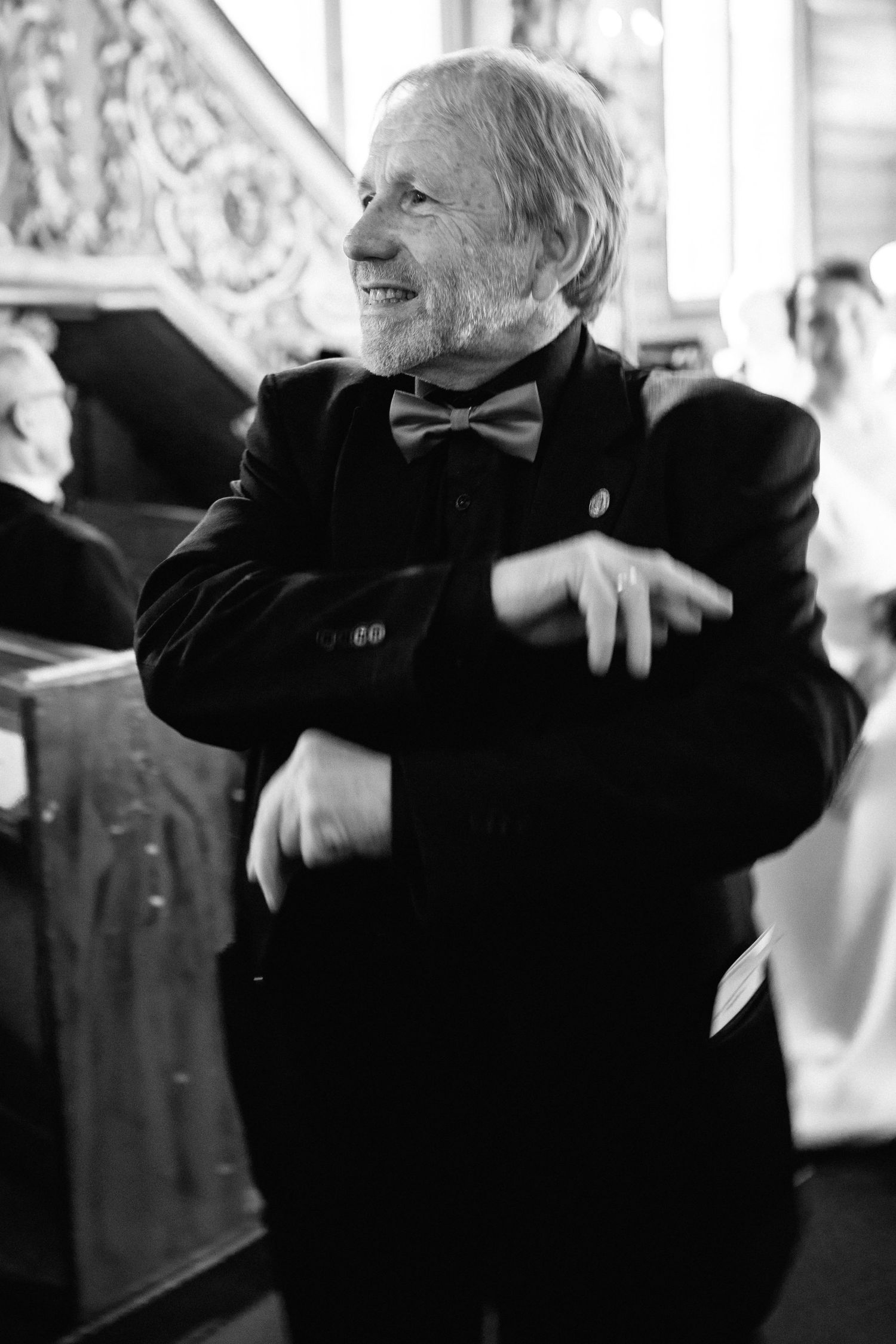 Elderly person in black attire expressing joy and laughter in a candid moment.