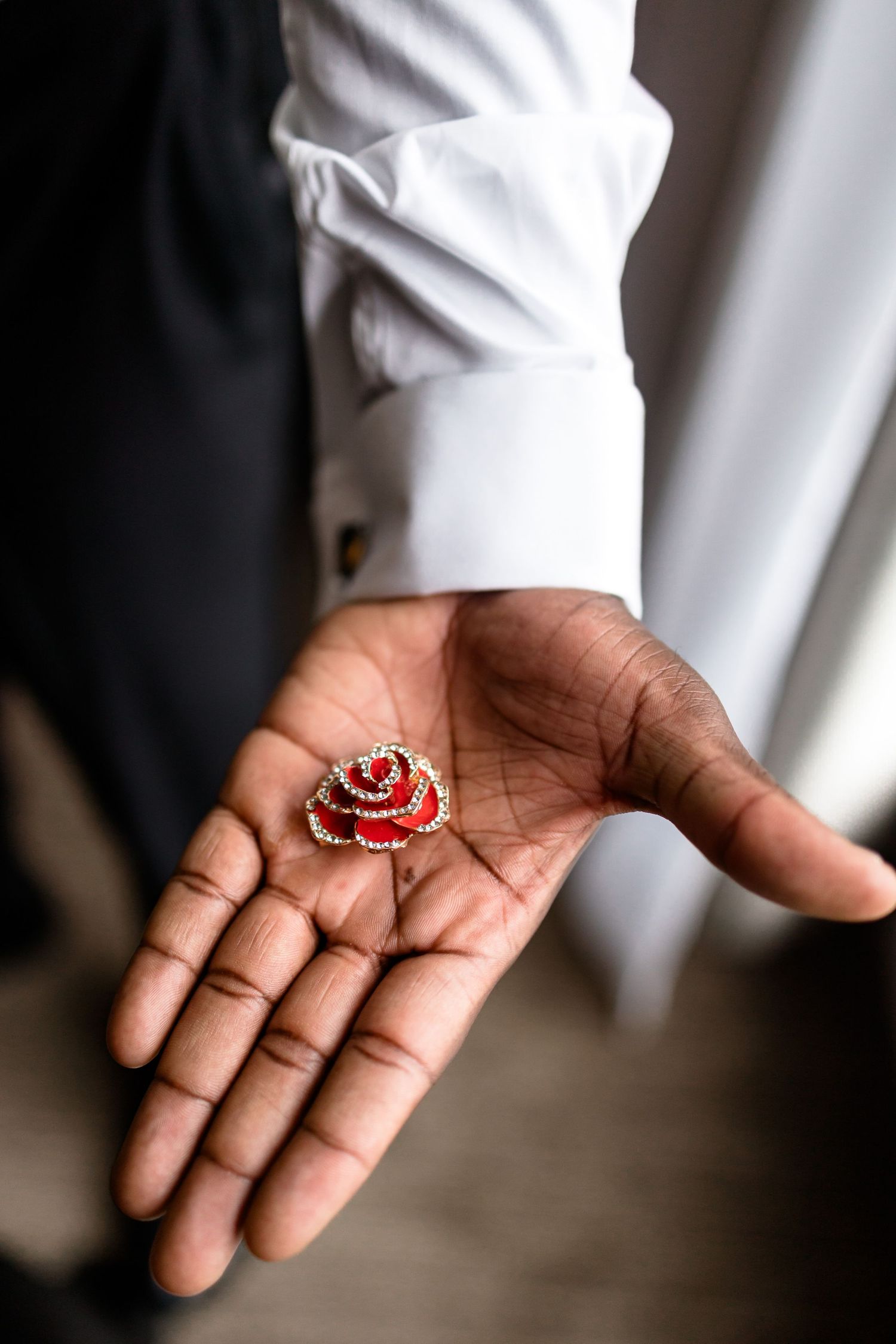 Close-up of hands holding delicate red and silver jewelry pieces.