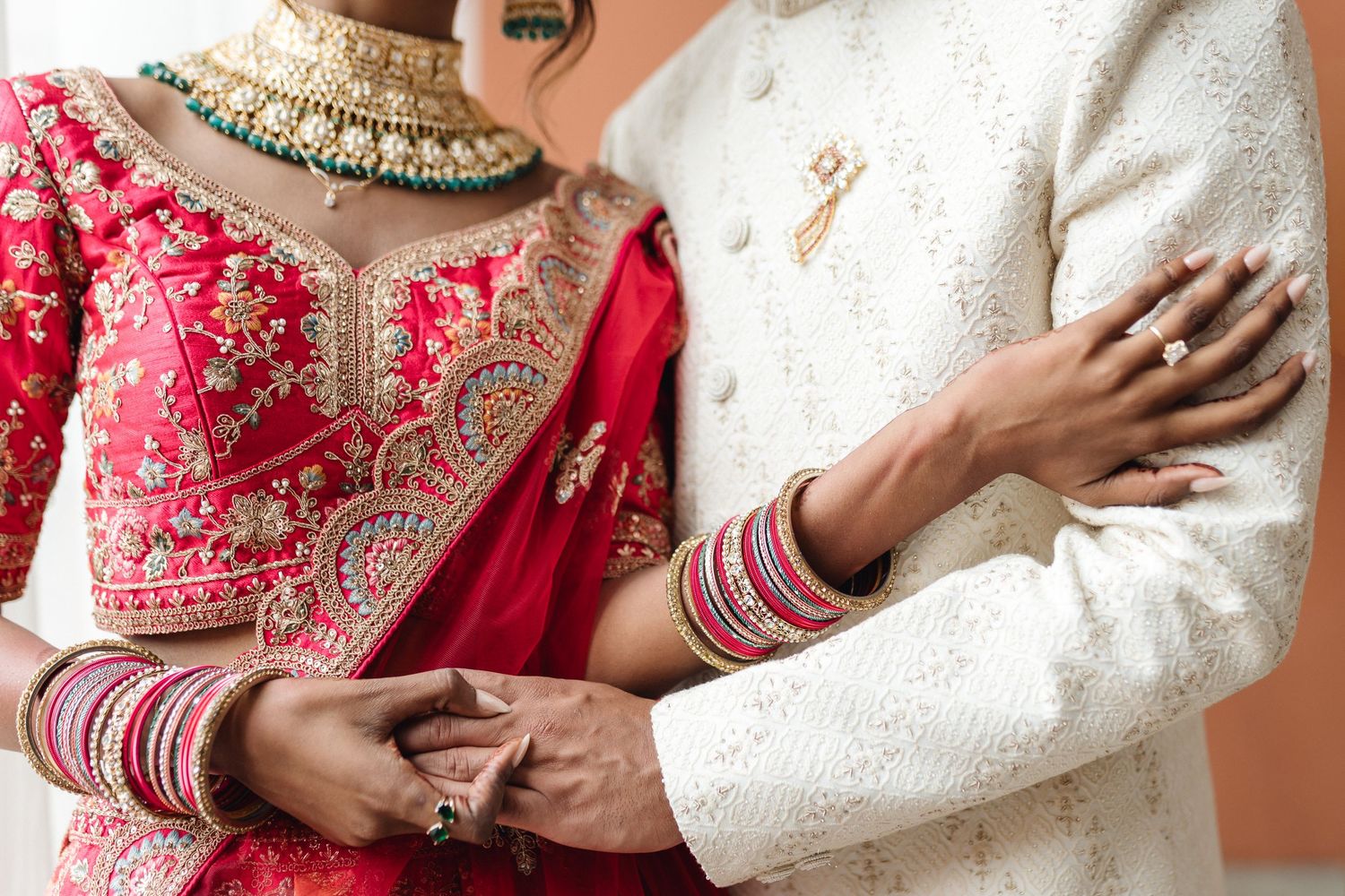 Close-up of traditional Indian wedding attire with detailed embroidery and jewelry.