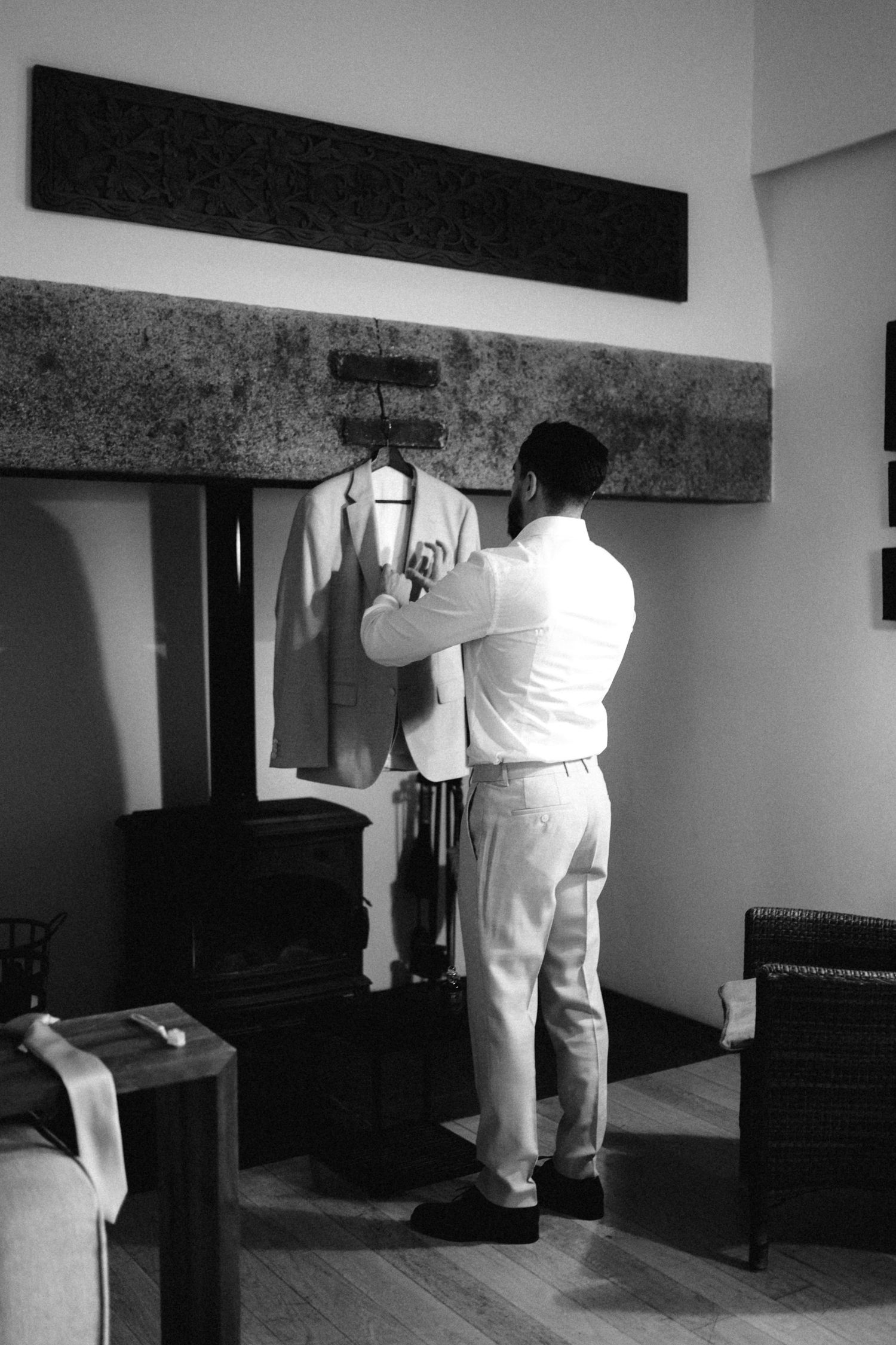 Black and white image of preparations taking place in a minimalist interior space.