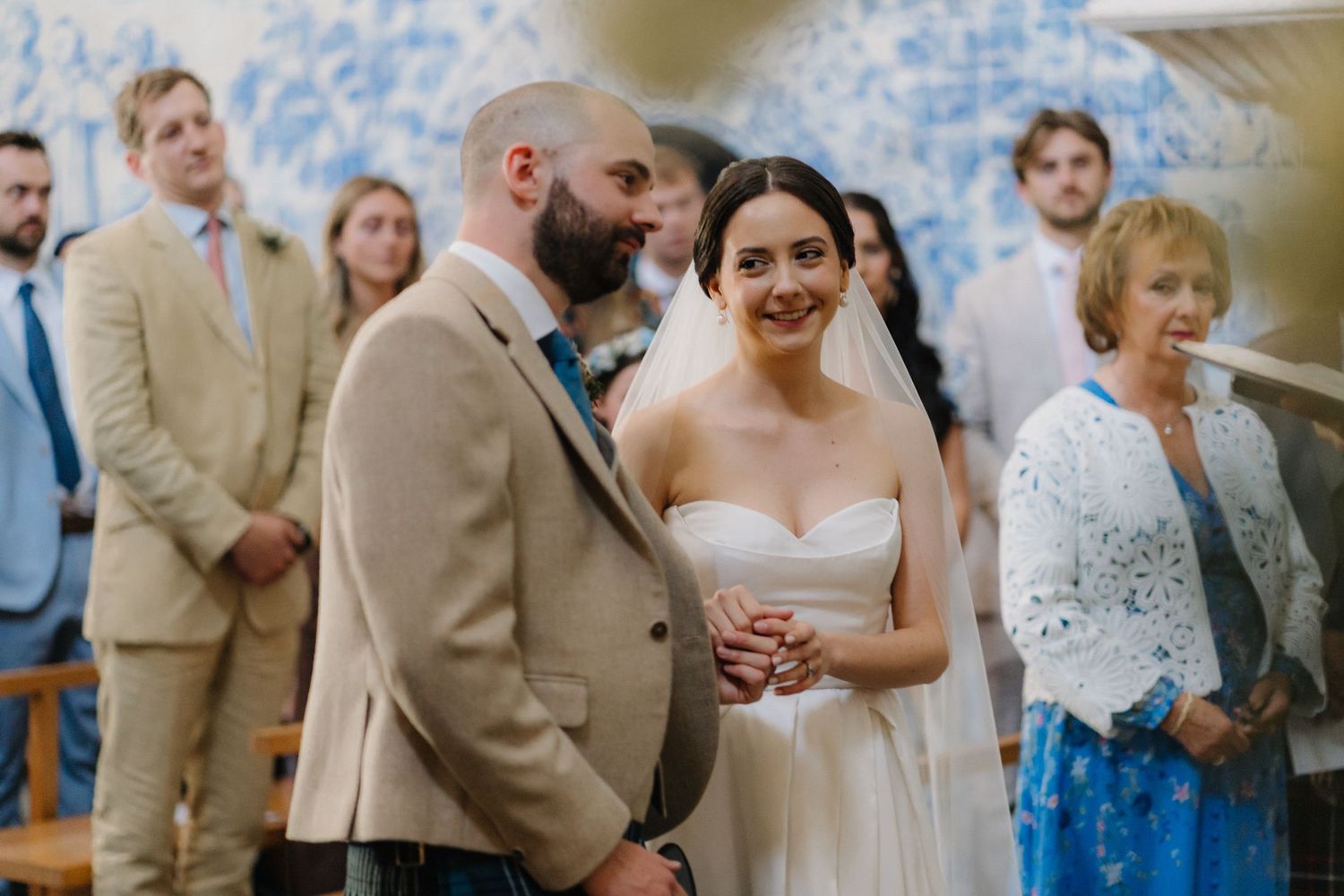 Joyful wedding celebration inside a historic chapel adorned with traditional Portuguese blue tiles.