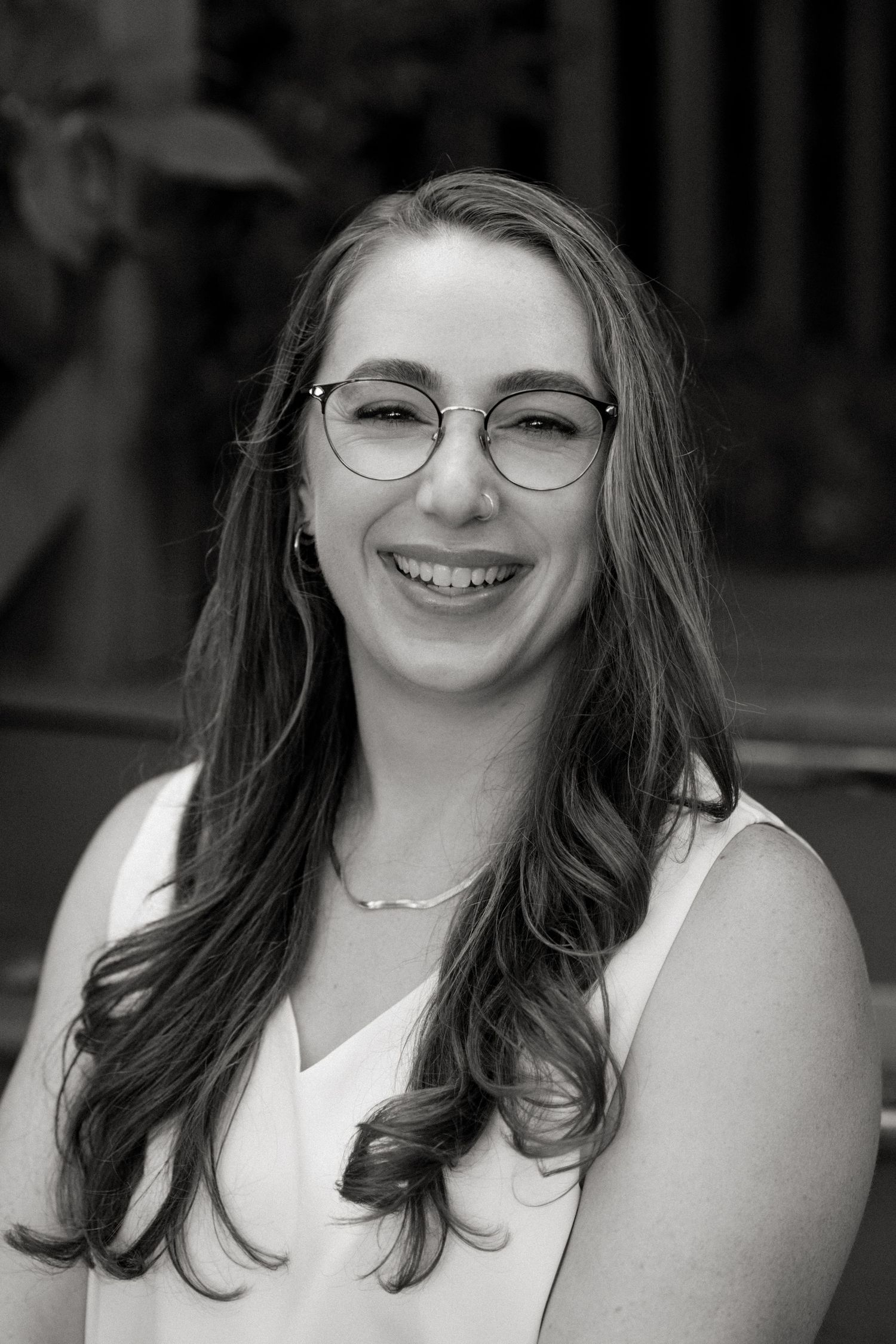 Black and white portrait series showing joyful expressions and glasses against a blurred background.