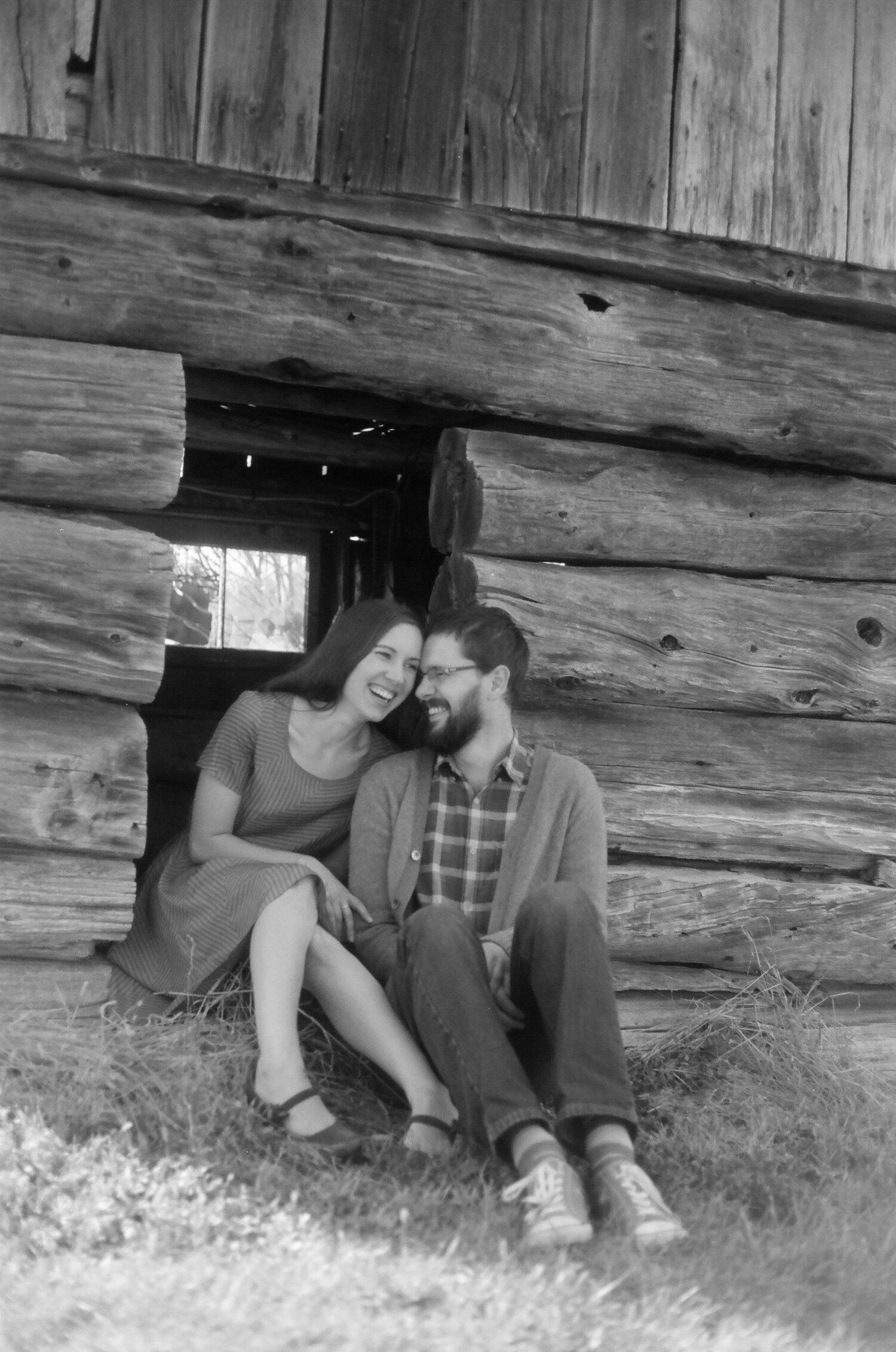Four sequential black and white images show a couple sitting close together under a rustic wooden structure.