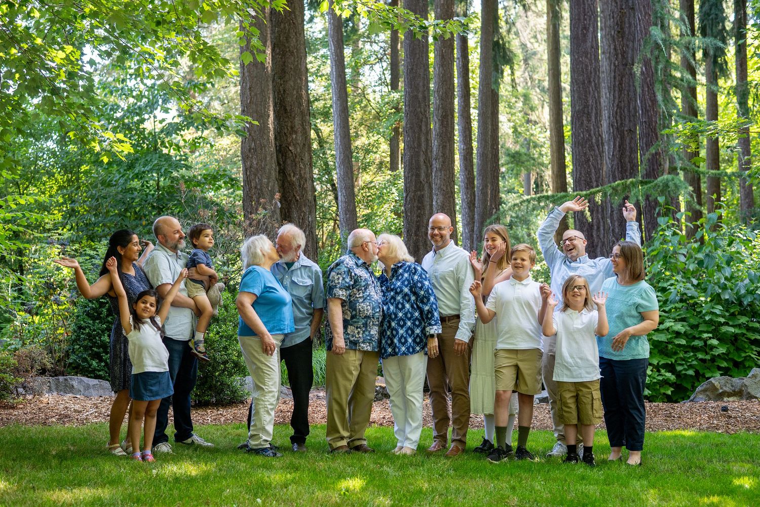 A group of visitors walk together through a lush green forest with tall trees during a nature tour.