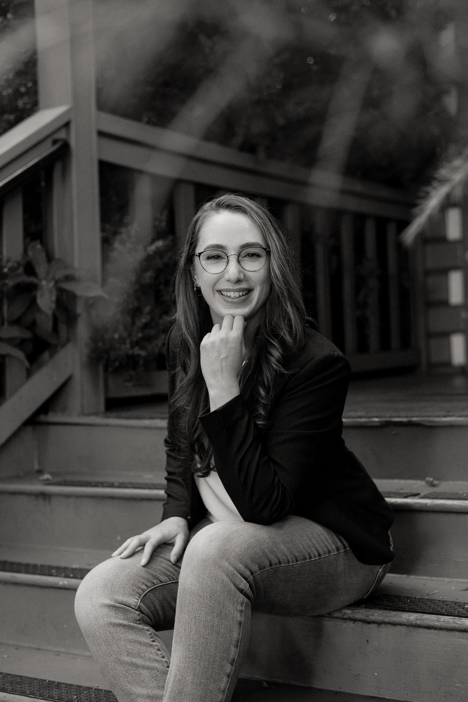 A black and white photo series showing a person in glasses and dark clothing sitting on wooden steps.