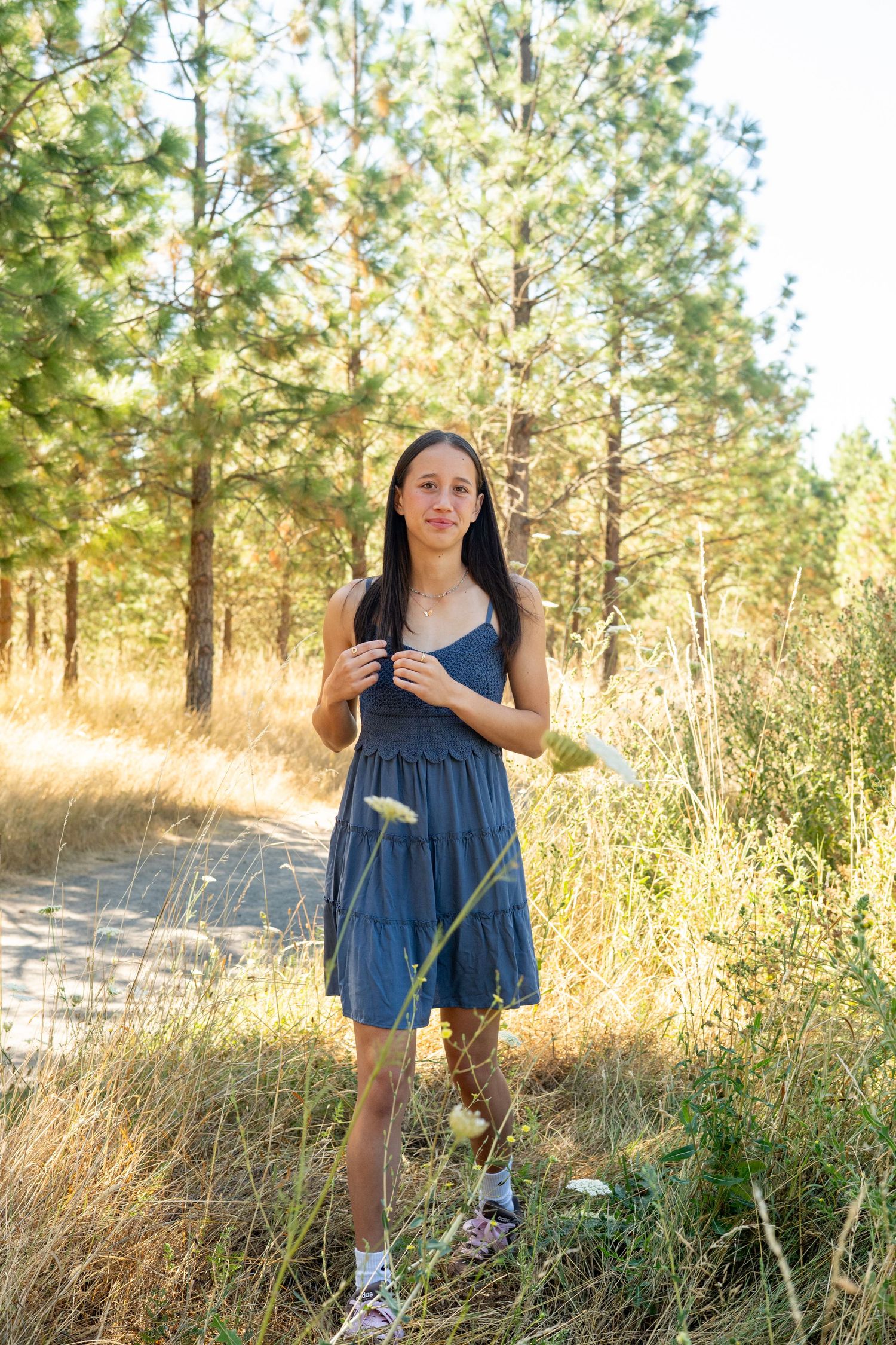 Four outdoor summer photos in a pine forest show someone wearing a denim dress against a backdrop of sunlit tall grass.