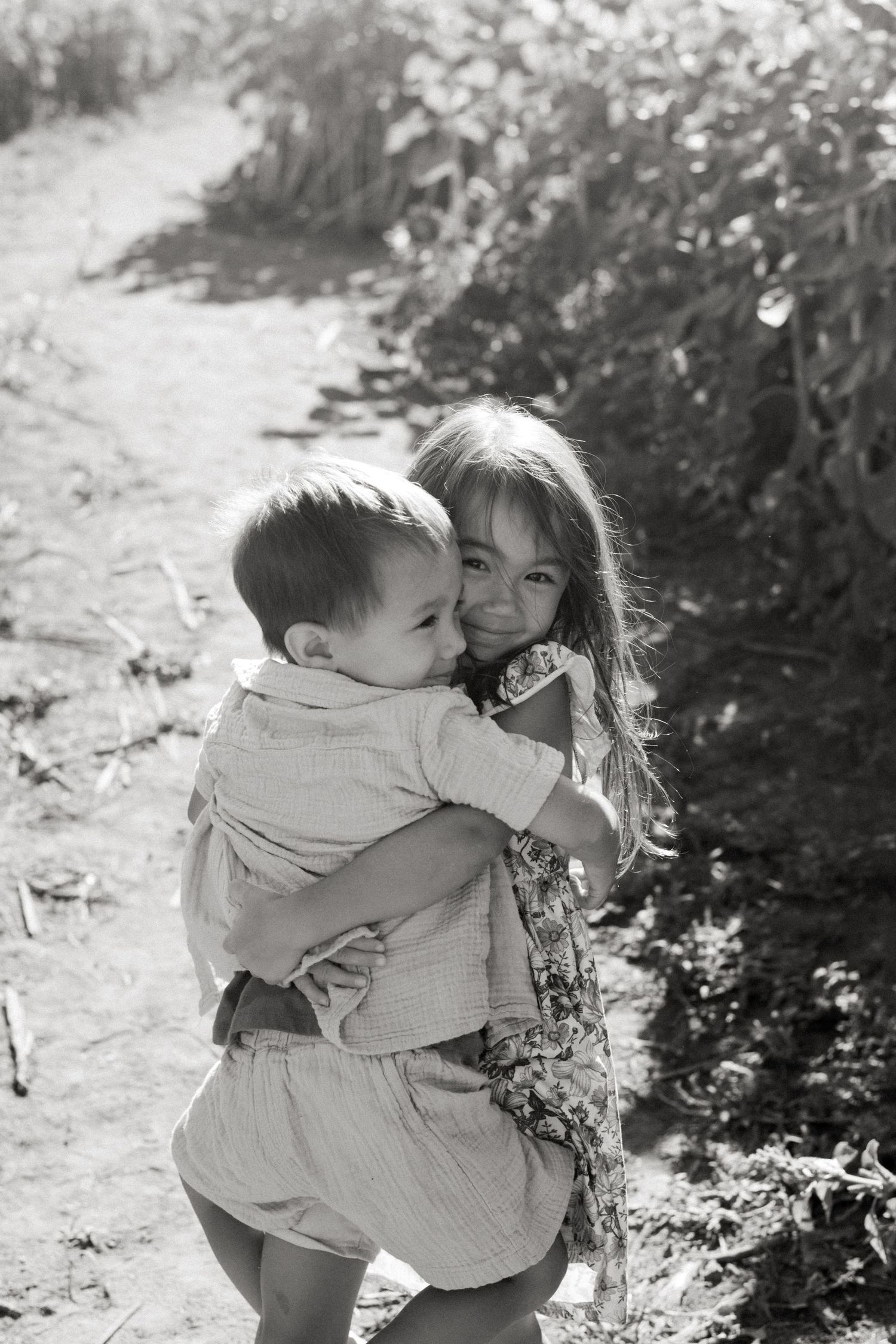 Black and white candid photos show tender moments between a parent and child embracing outdoors.