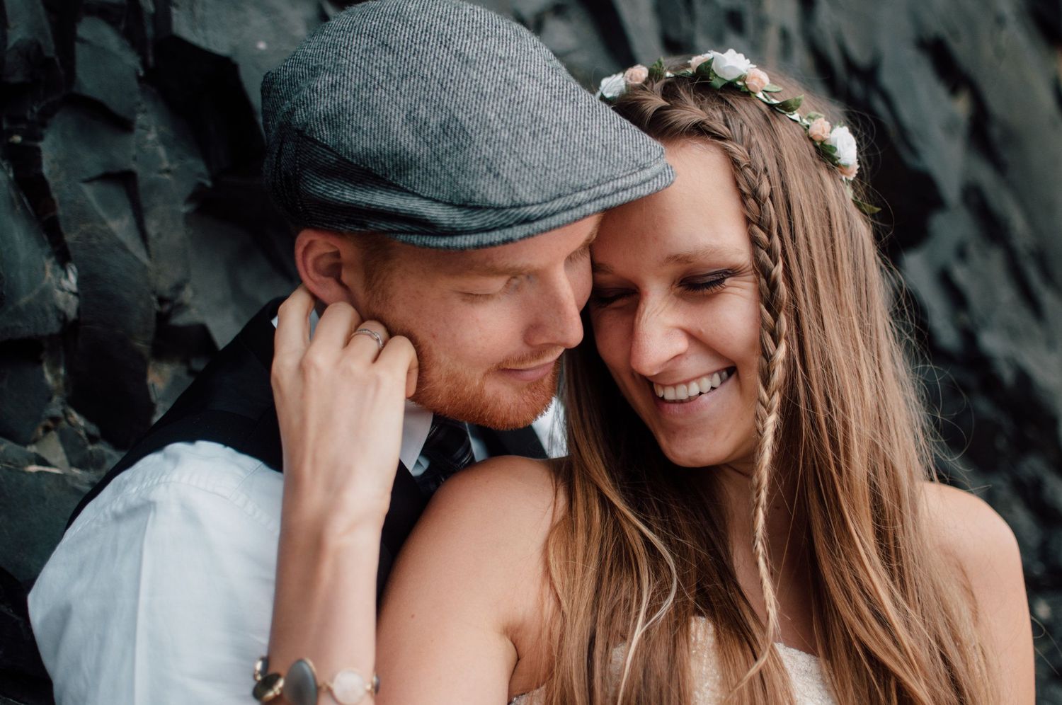 An intimate moment between a couple, with one wearing a flat cap.