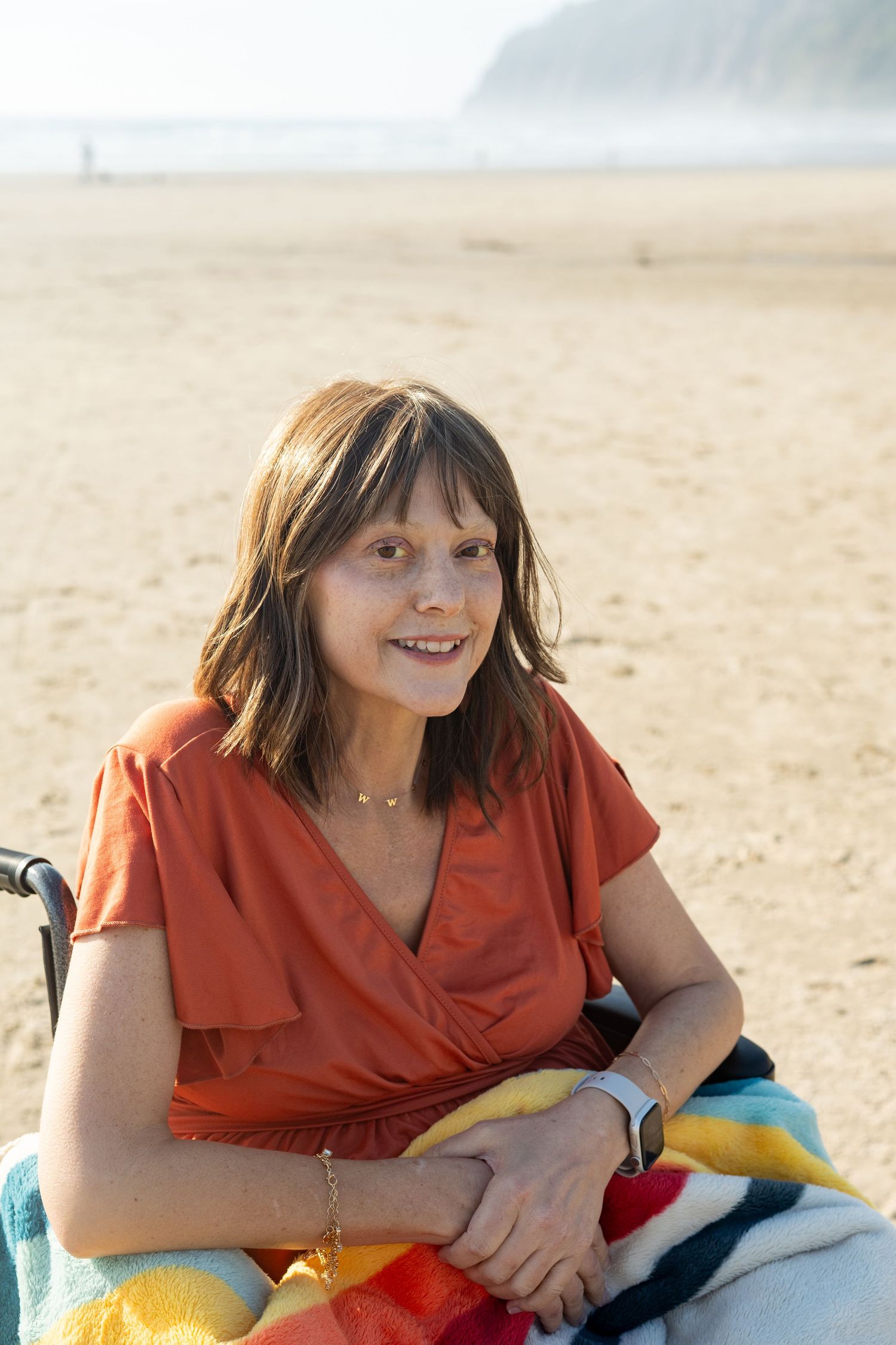 Someone in a bright orange top relaxing on a sandy beach, shown in a sequence of casual poses.