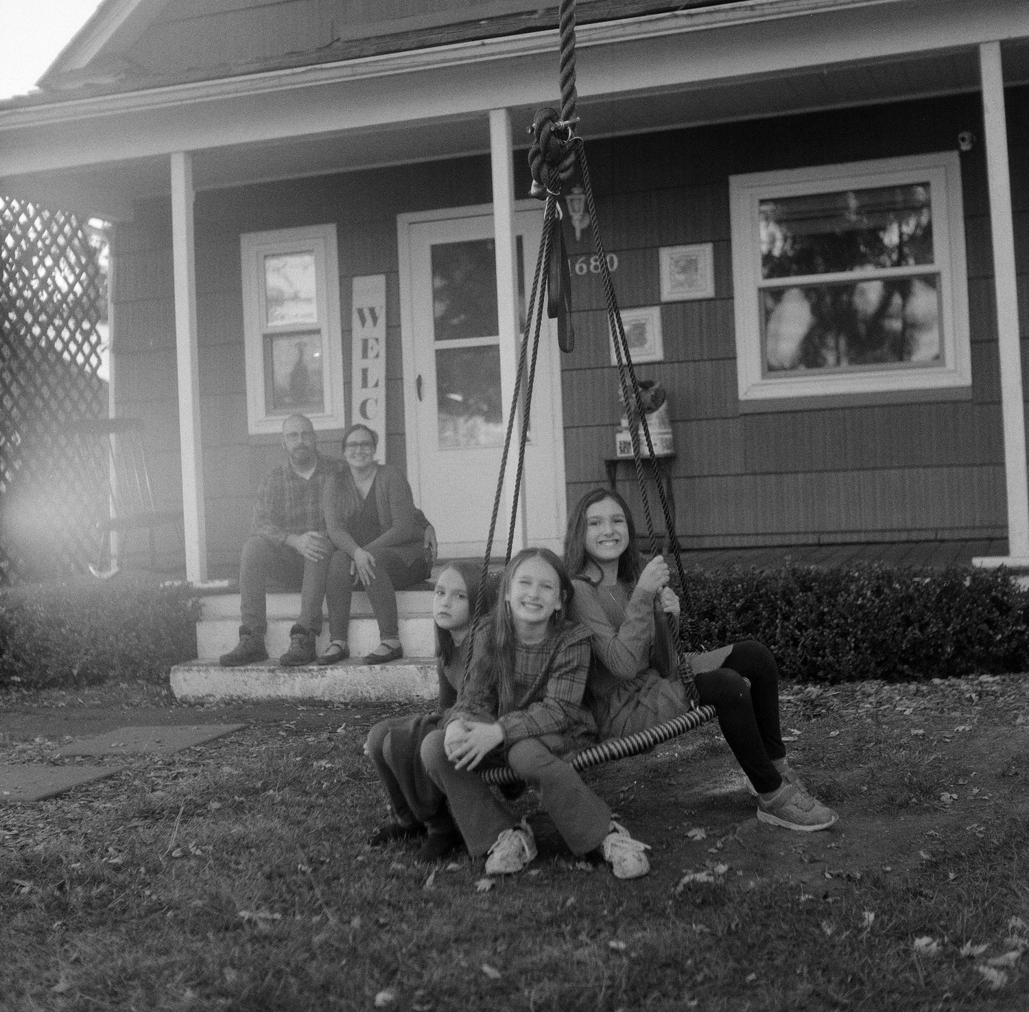 A series of black and white images showing people relaxing on a porch step.