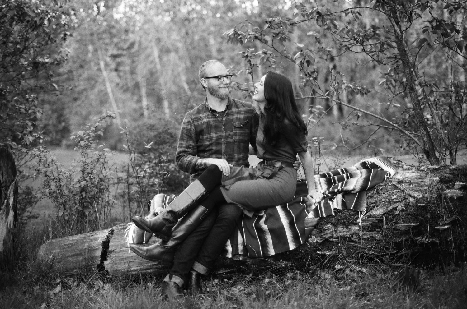 Vintage black and white photos showing outdoor camping scenes with people relaxing in nature beside a fire.
