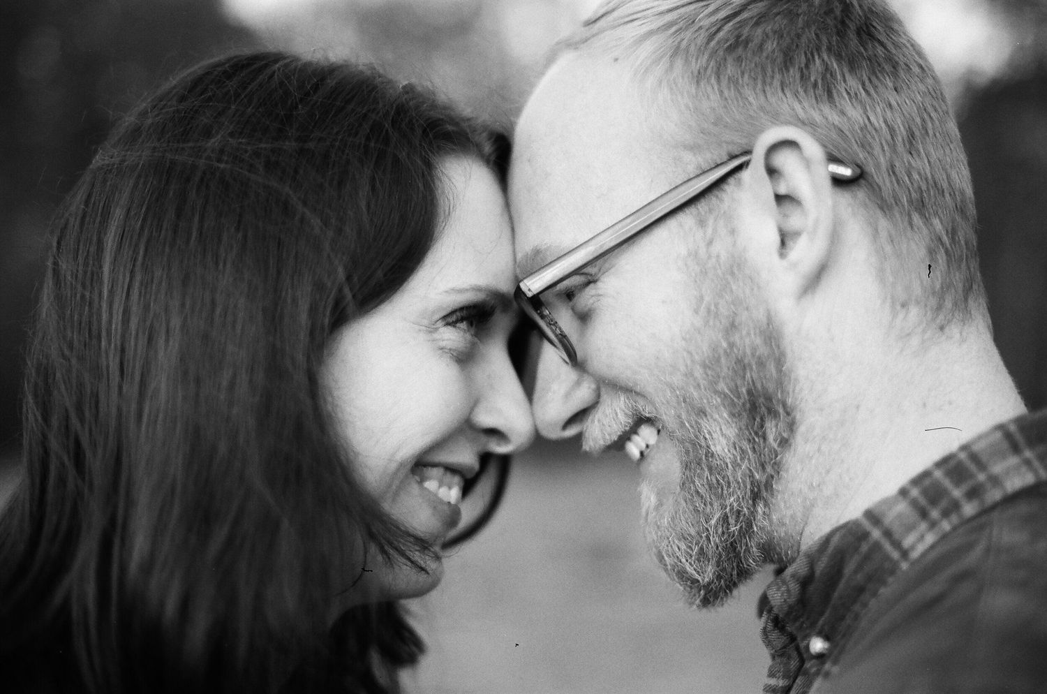 Black and white intimate portrait of a couple with foreheads touching and sharing a tender moment together.