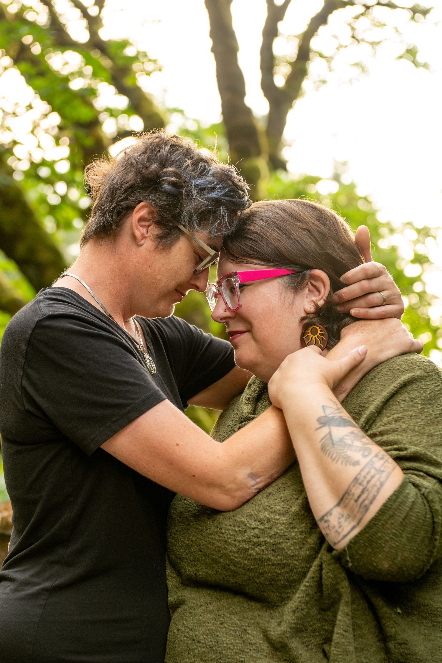 A series of four intimate moments captured outdoors showing two people embracing under greenery and natural lighting.