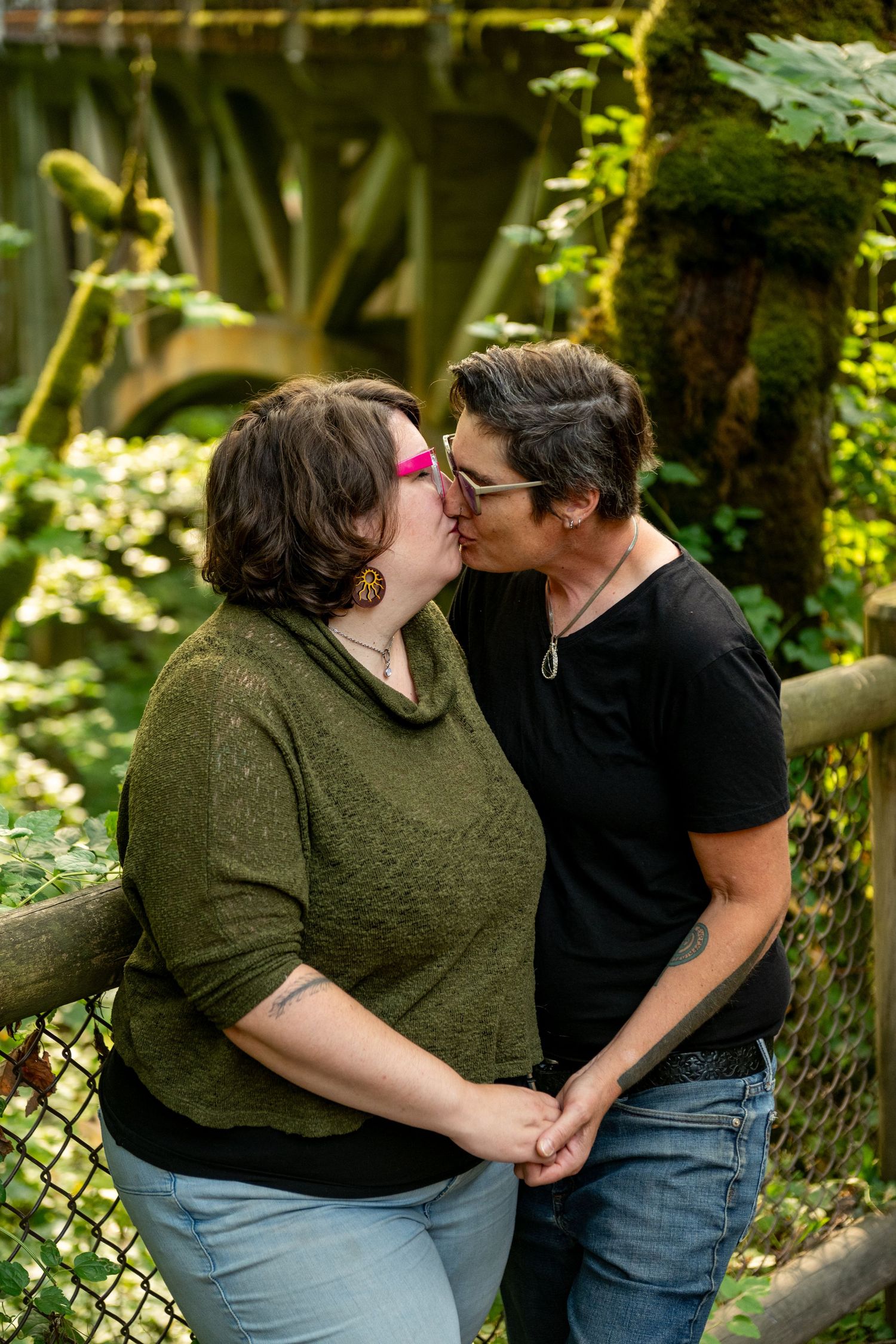A romantic outdoor photo session in a garden setting showing couple sharing tender moments against green foliage background.