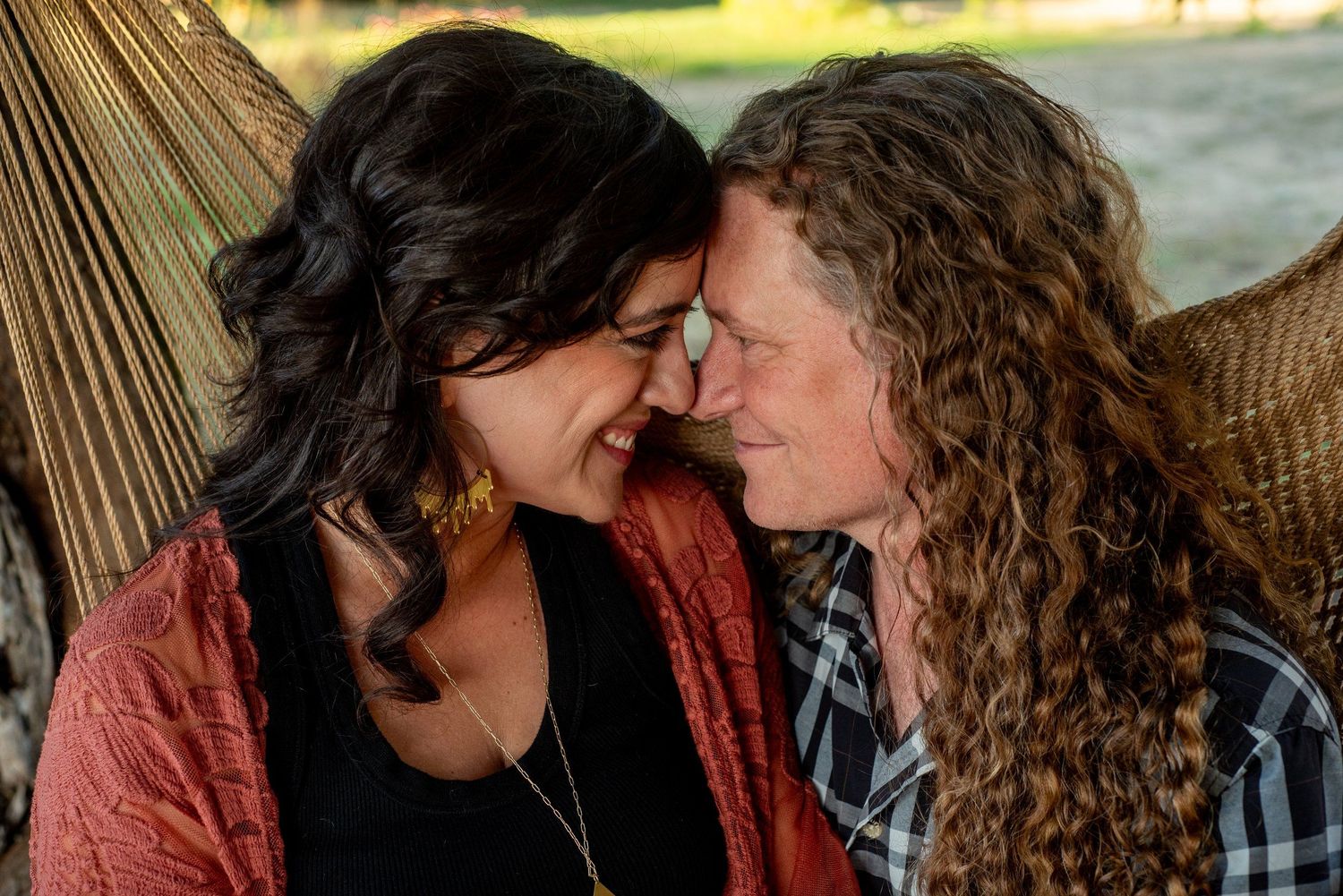 A tender moment between two people with curly hair sharing an intimate embrace.