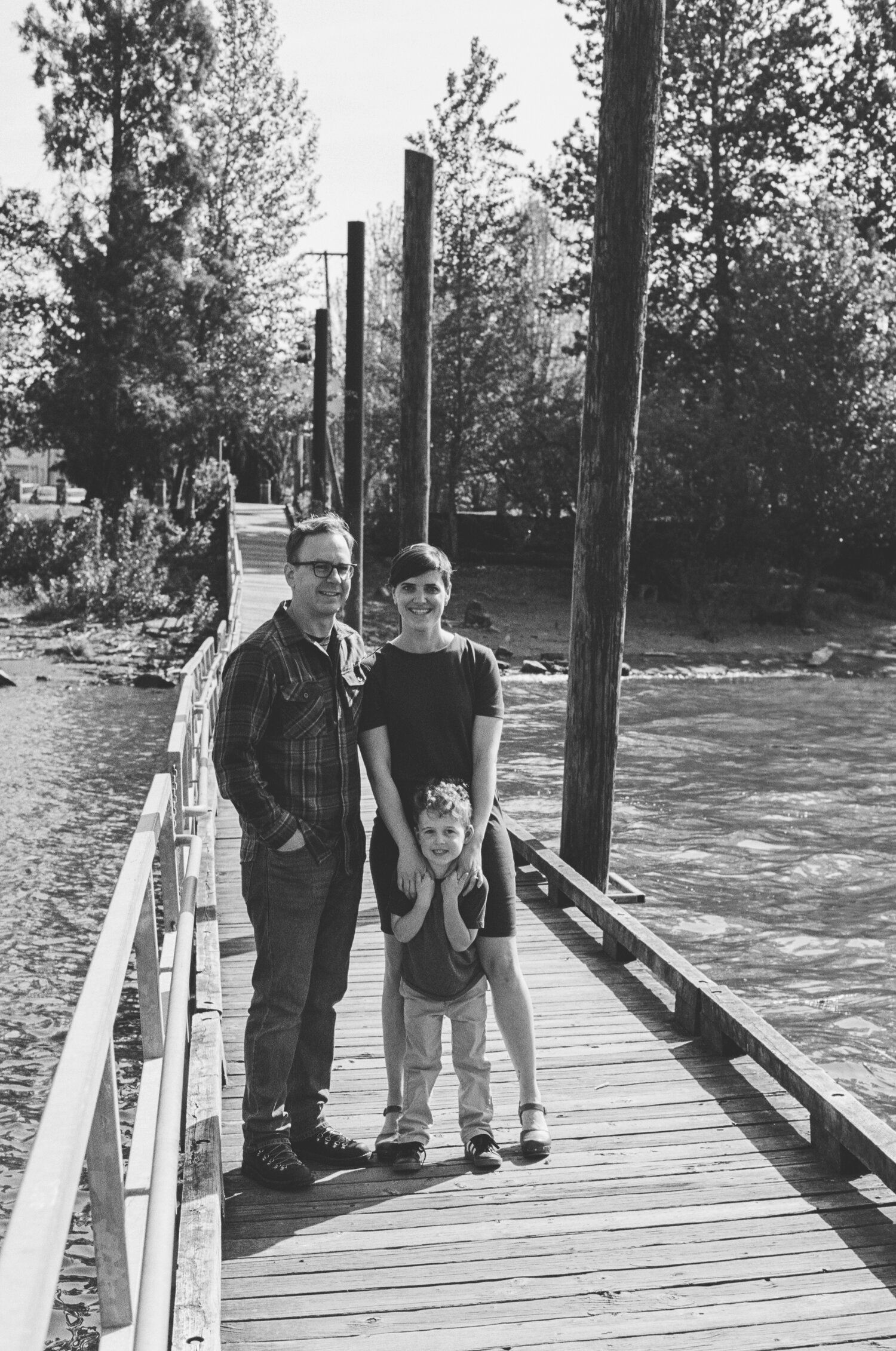 Three black and white photos show people standing on a wooden dock with railings during what appears to be a sunny day.