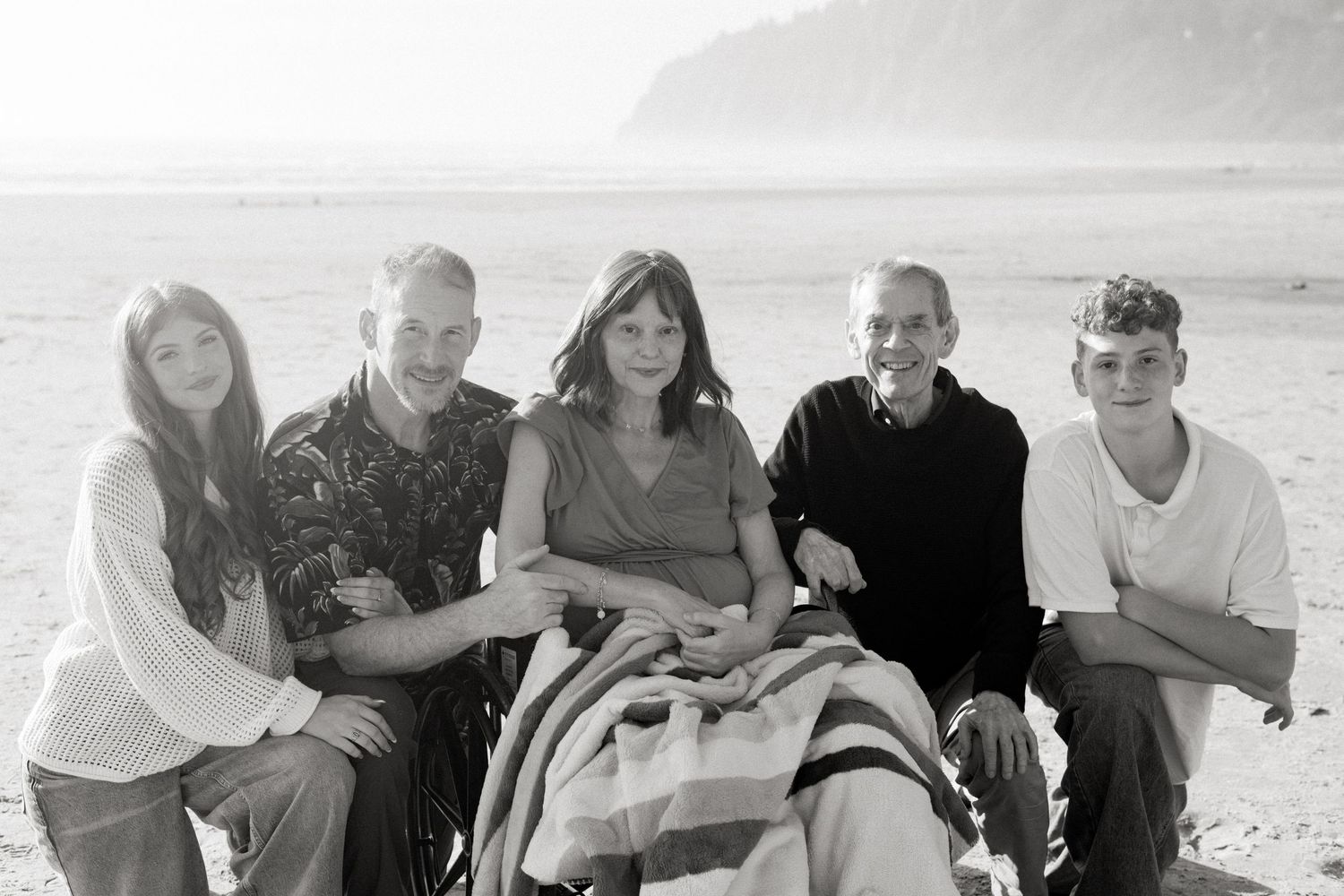 A black and white panoramic sequence shows a group enjoying a sunny day at the beach during a joyful outing.