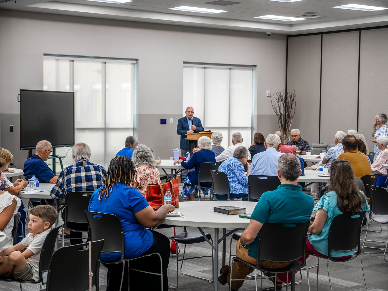 Commercial photographer capturing a corporate keynote speaker presenting to a seated audience at a Warner Robins GA business event.