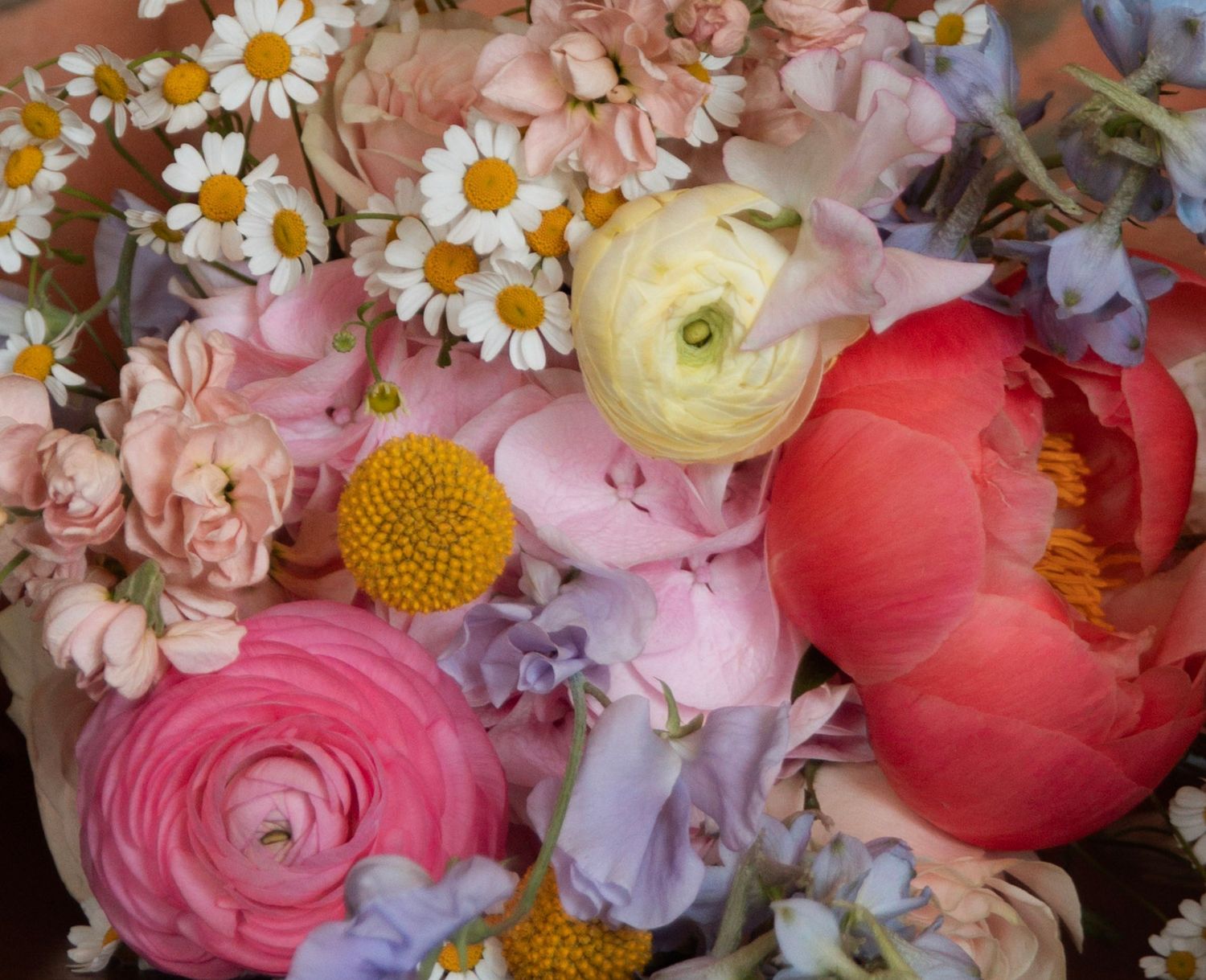 Colorful bouquet with peonies, ranunculus, daisies, and delphinium flowers.