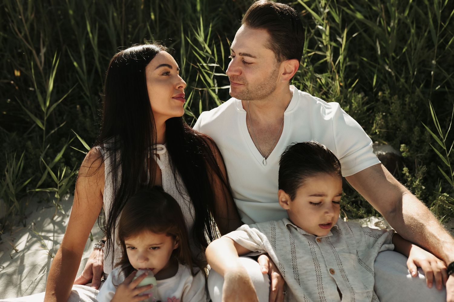 Family of four seated together outdoors, Sydney family photography