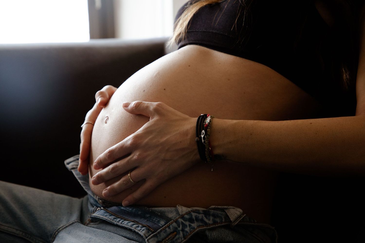 Close-up of pregnant belly with hands cradling bump, Sydney maternity photography