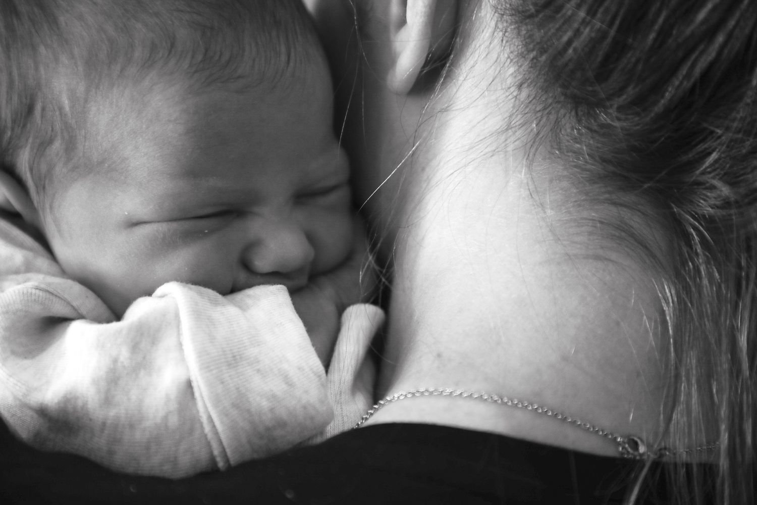 Black and white portrait of newborn baby resting on parent's shoulder, Sydney newborn photography