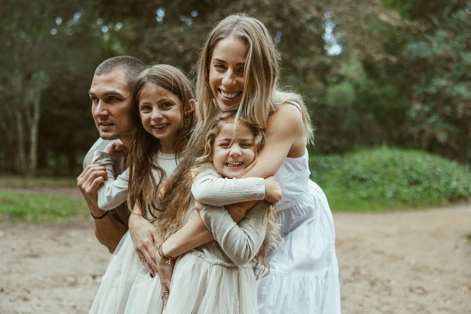 Family of four embracing together in woodland setting, Sydney family photography