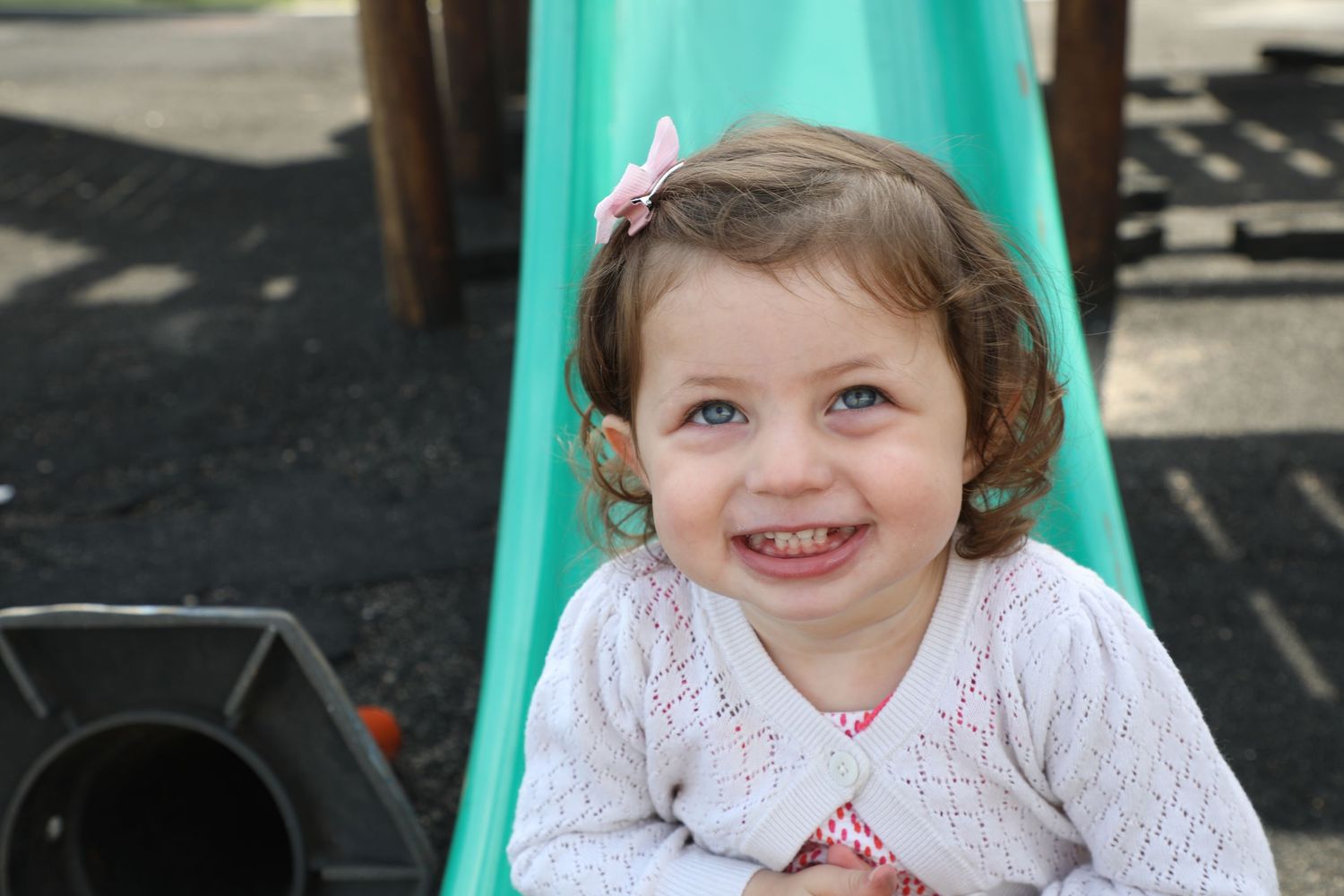 Toddler girl smiling on outdoor slide, Sydney family photography