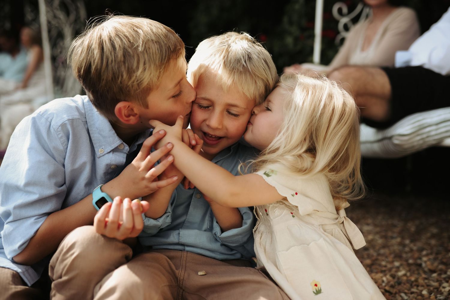 Three young cousins embracing and laughing together outdoors, Sydney family photography
