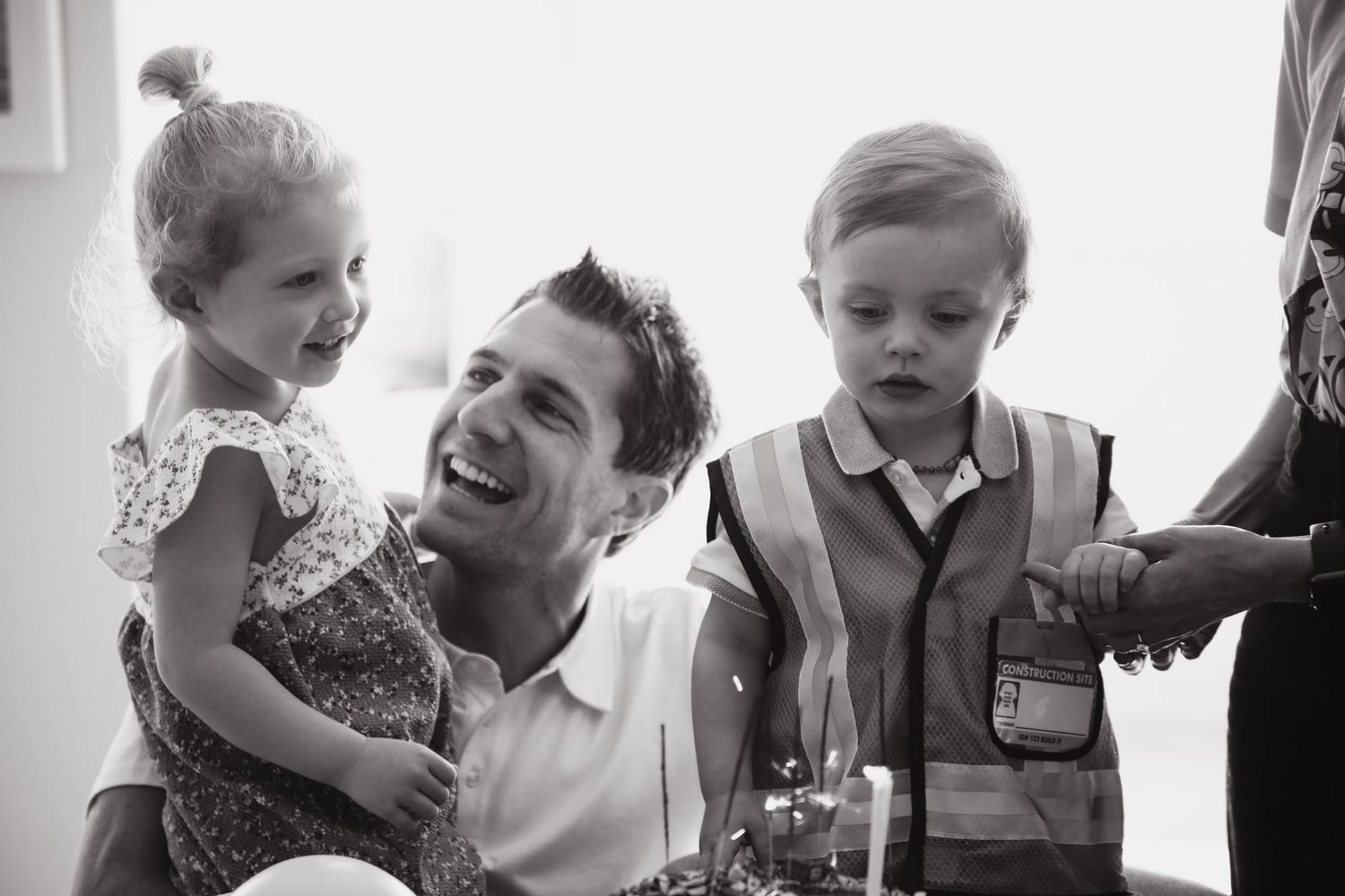 Black and white portrait of father laughing with two children at family birthday. Sydney family photography