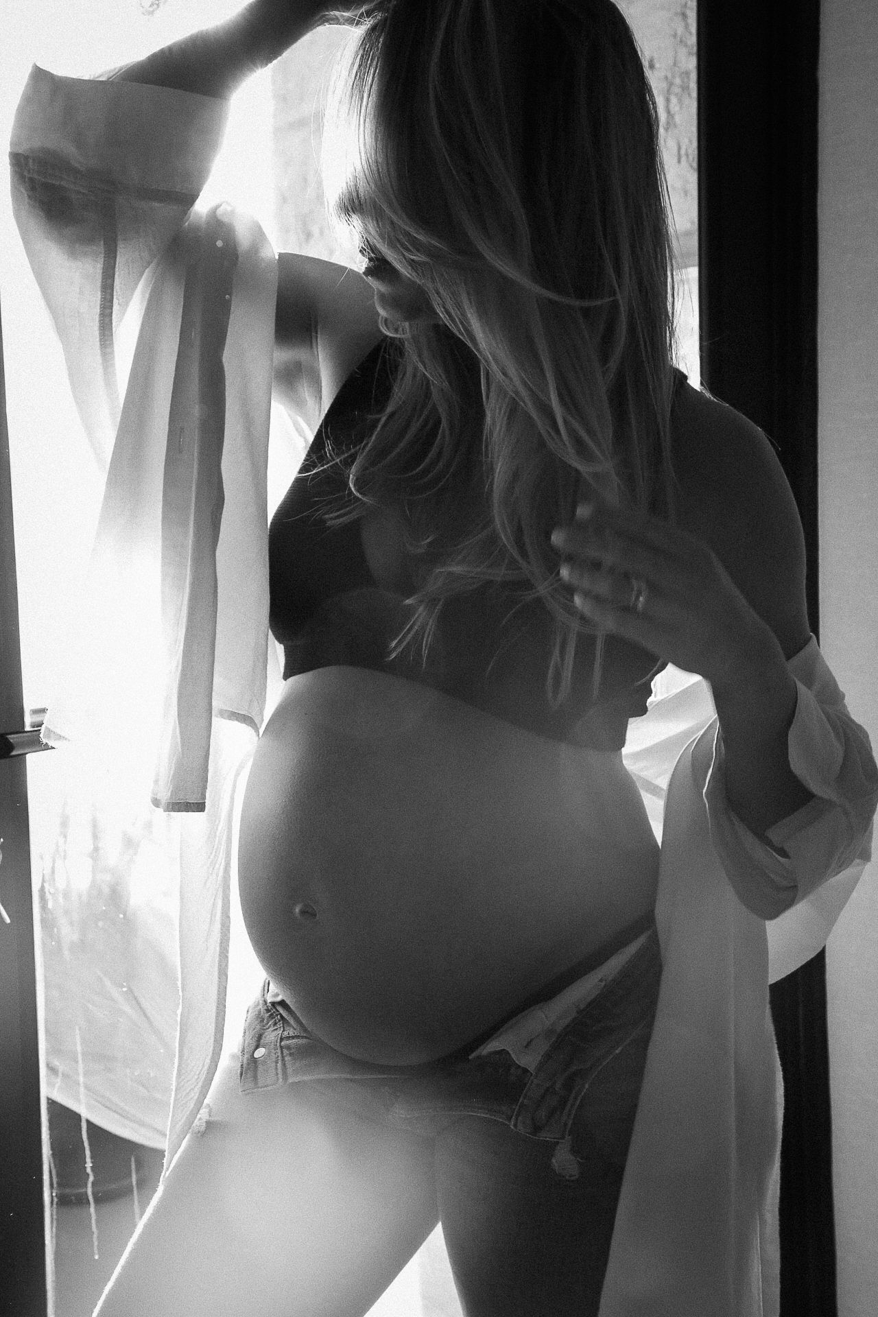 Black and white maternity portrait of pregnant woman in soft window light, Sydney