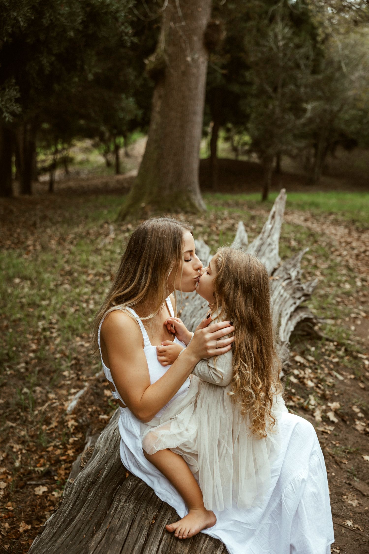 Mother and daughter embracing in autumn woodland setting, Sydney family photography