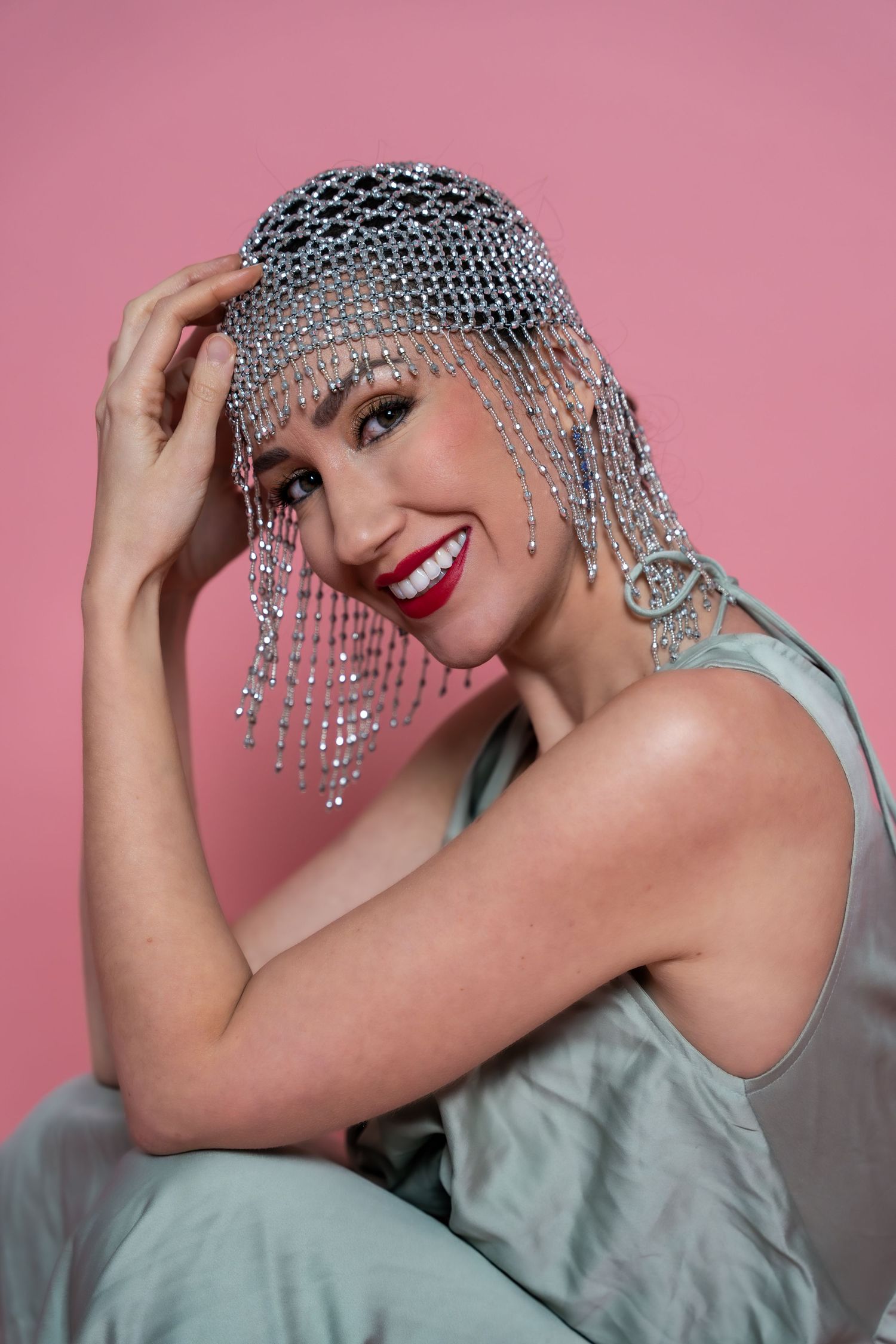 Creative Valentine's portrait of a woman in a beaded headpiece on a pink backdrop, by Anya MacLaren Photography