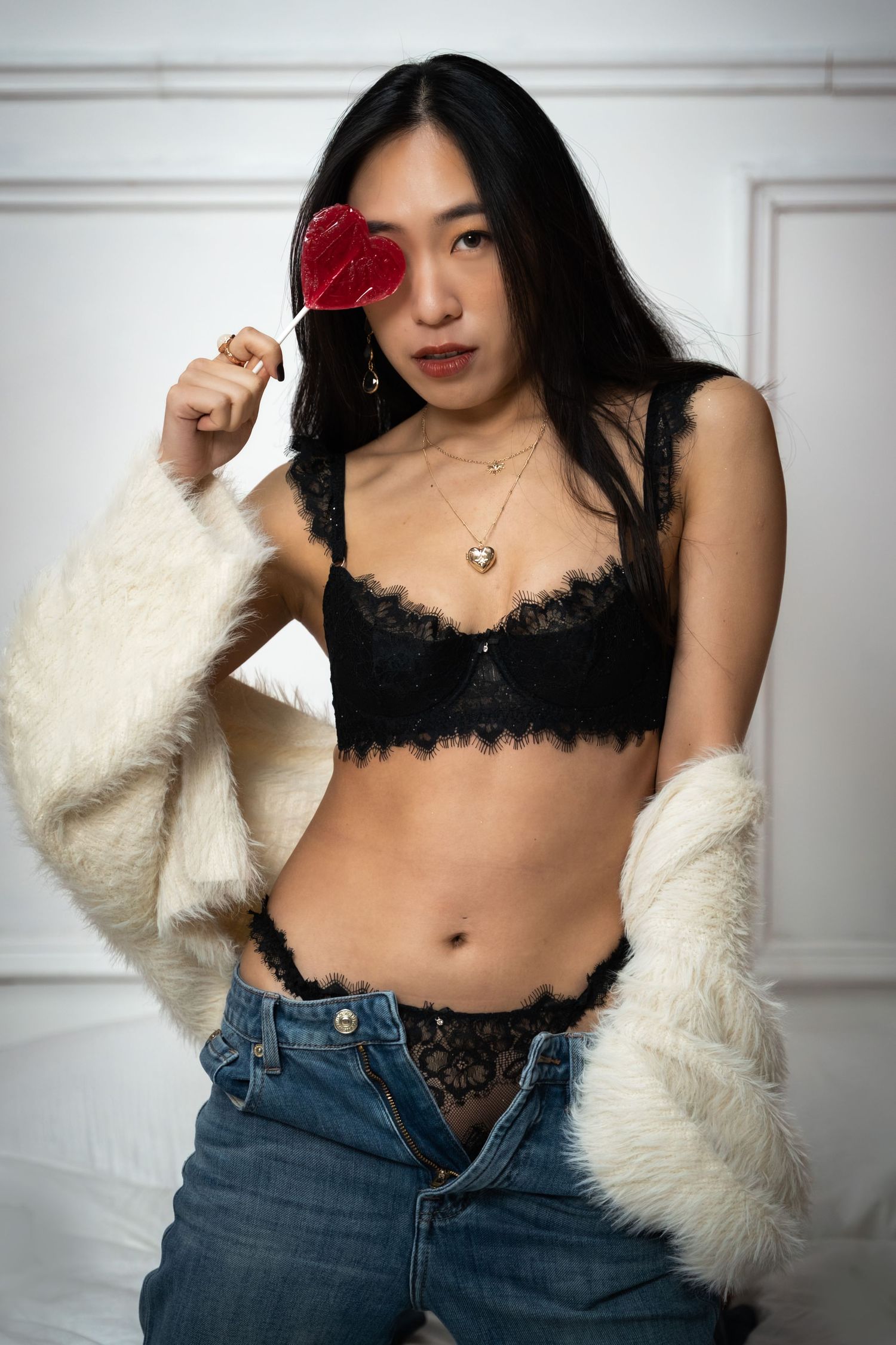 Valentine's boudoir portrait in black lace lingerie with a heart-shaped lollipop, by Anya MacLaren Photography