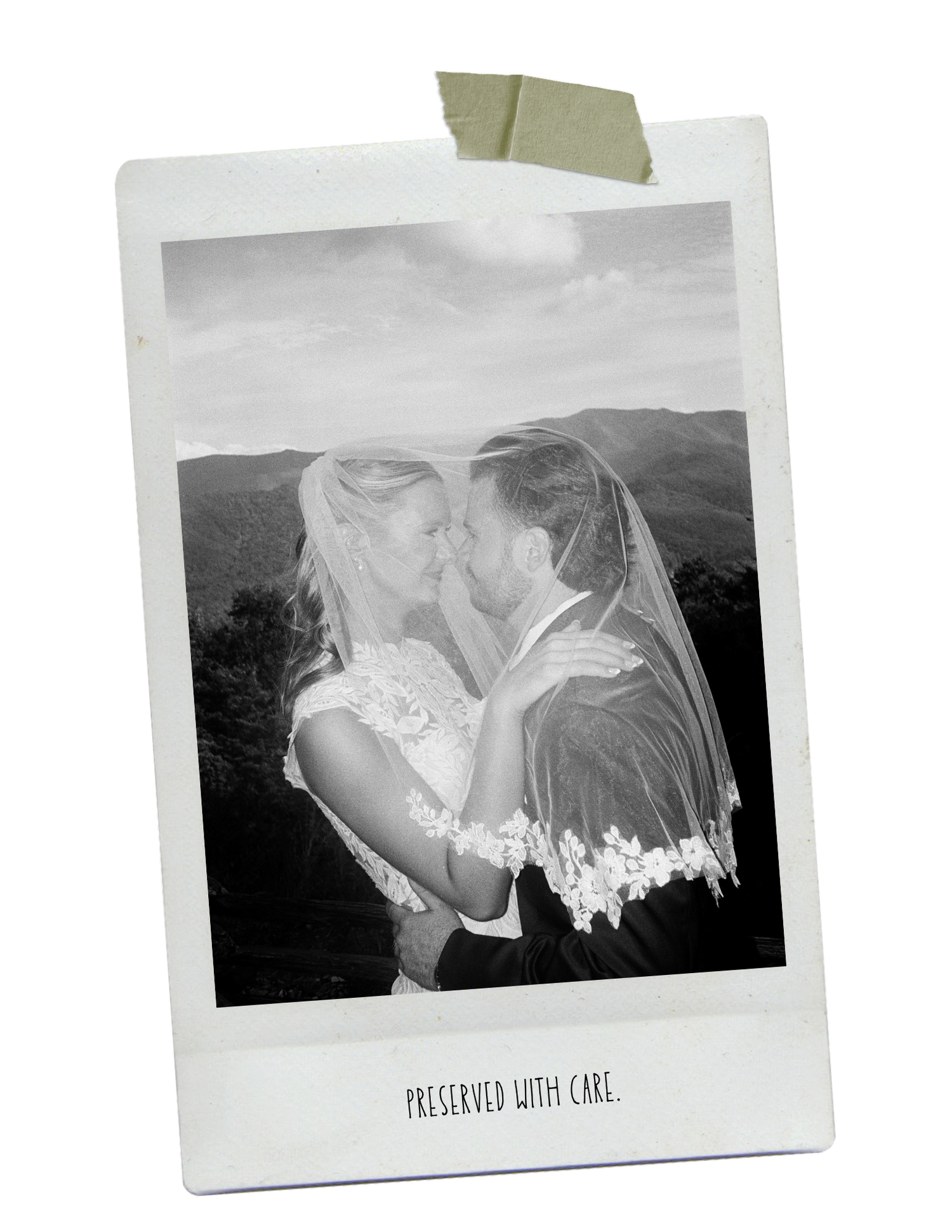 Black and white Polaroid photo of a bride and groom sharing a romantic kiss outdoors with mountains in the background.