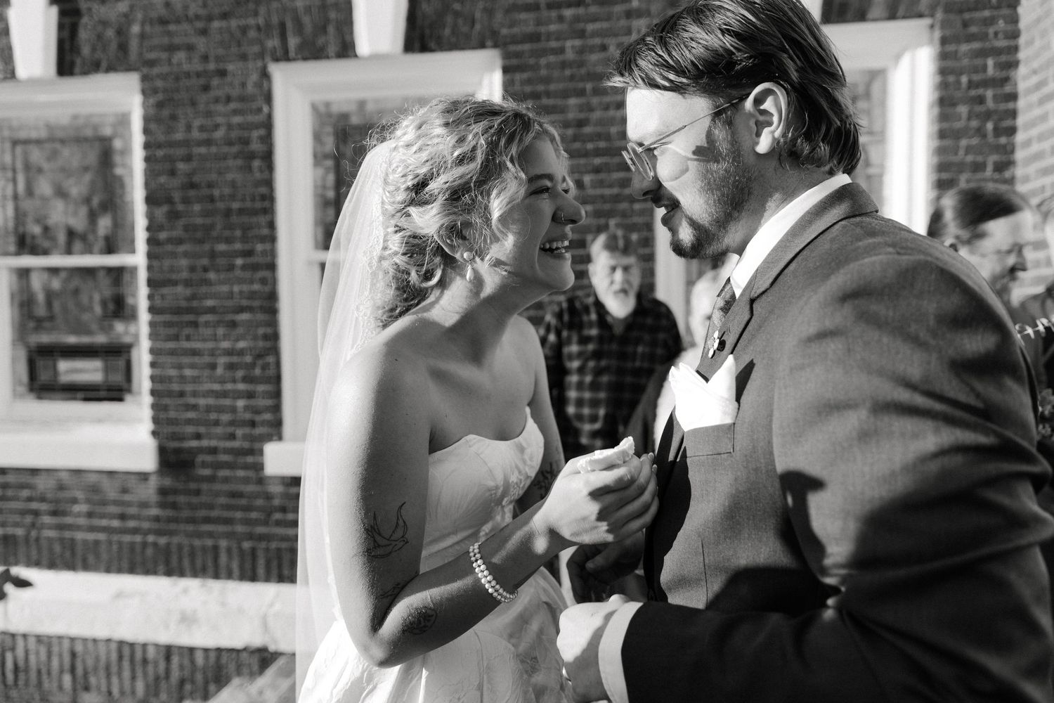 Black and white photo of a bride and groom sharing a tender moment during their wedding ceremony.