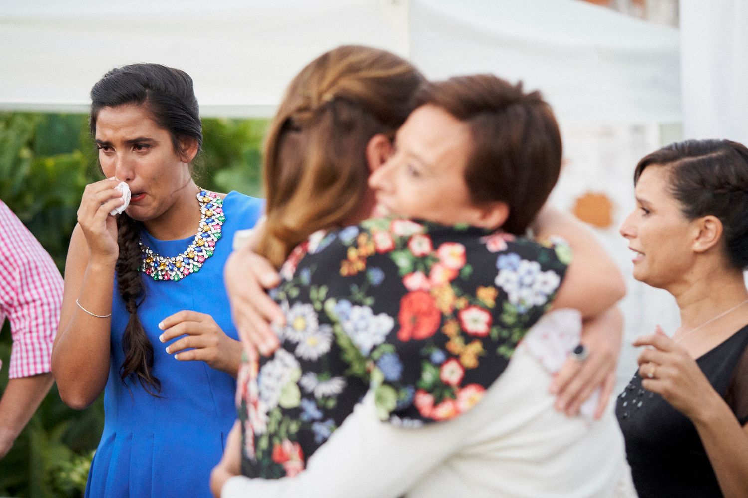Invitada emocionada secándose una lágrima con un pañuelo durante la boda