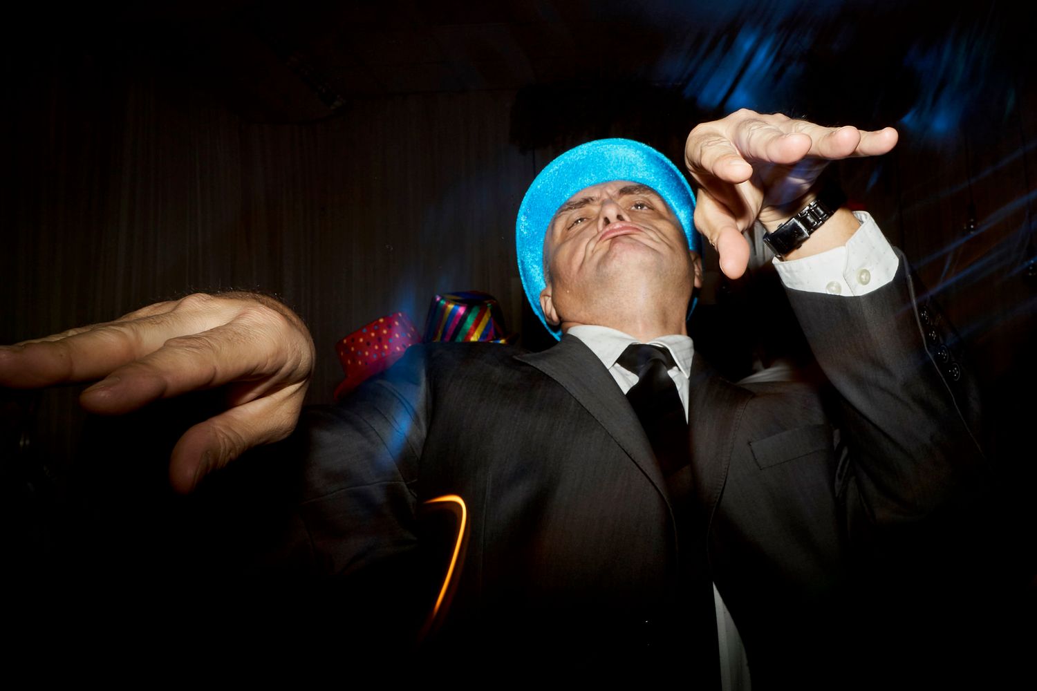 Invitado con sombrero azul de fiesta bailando de manera divertida en la pista