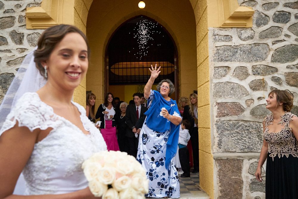 Madre de la novia arrojando arroz a los recién casados en la salida de la iglesia