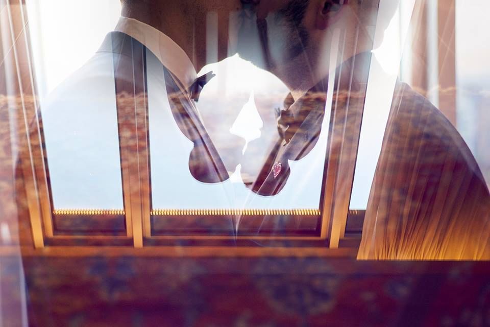 Doble exposición artística de una pareja besándose junto a una ventana con tonos cálidos