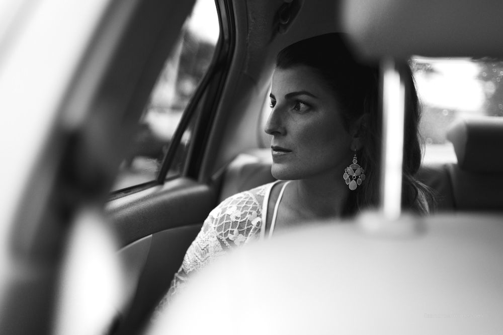 Foto en blanco y negro de una invitada mirando por la ventanilla de un auto