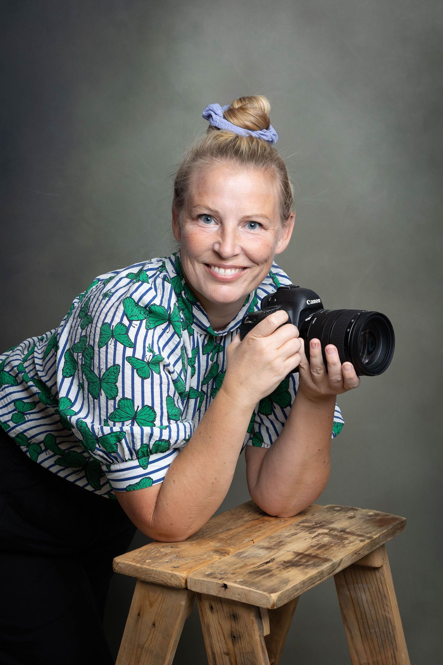 Selvportrett av Trine Lybekk fotografen bak Trinefaktor. Holder kamera og smiler. Portrettfotografering i studio ved Lillestrøm.