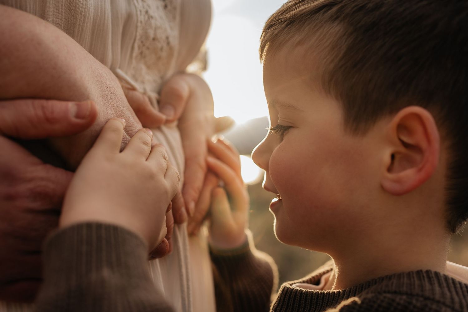 A series of tender close-up shots showing a mother kissing her young child in warm, natural lighting.