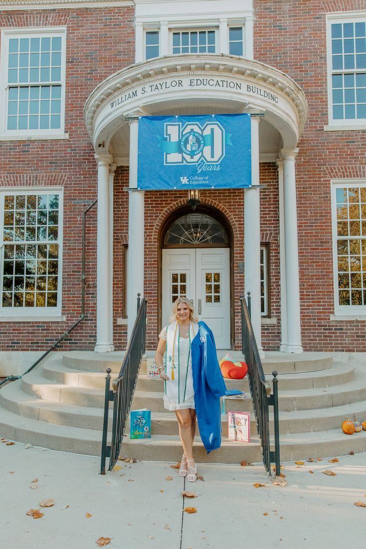 Taylor Education Building entrance at University of Kentucky with blue centennial banner and graduation decorations.