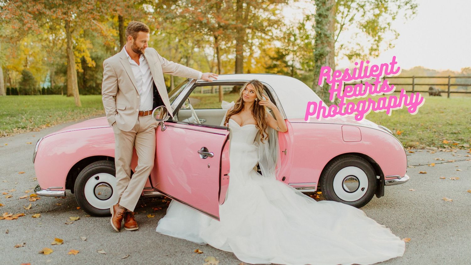 A vintage pink golf cart decorated with flowers parked on a tree-lined path during an autumn wedding photoshoot.