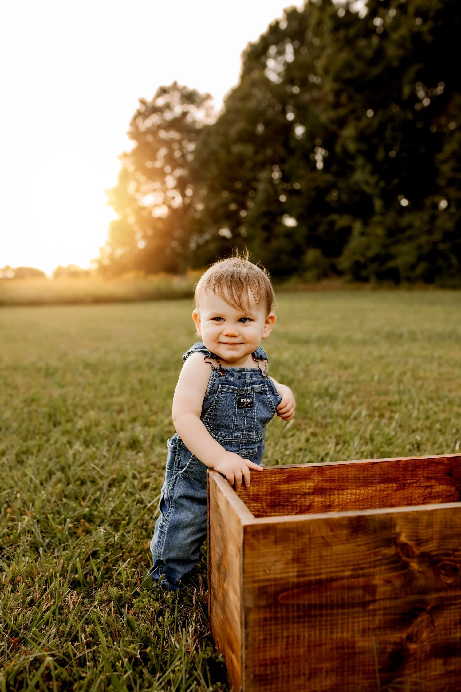 Baby boy in field during lifestyle session with natural light in Denver NC