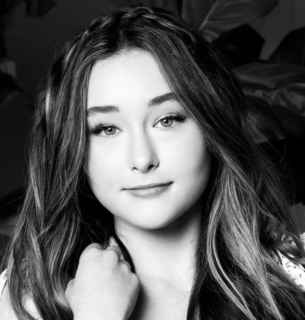 Personal branding headshot pre teen black and white slight smile with hand next to her neck